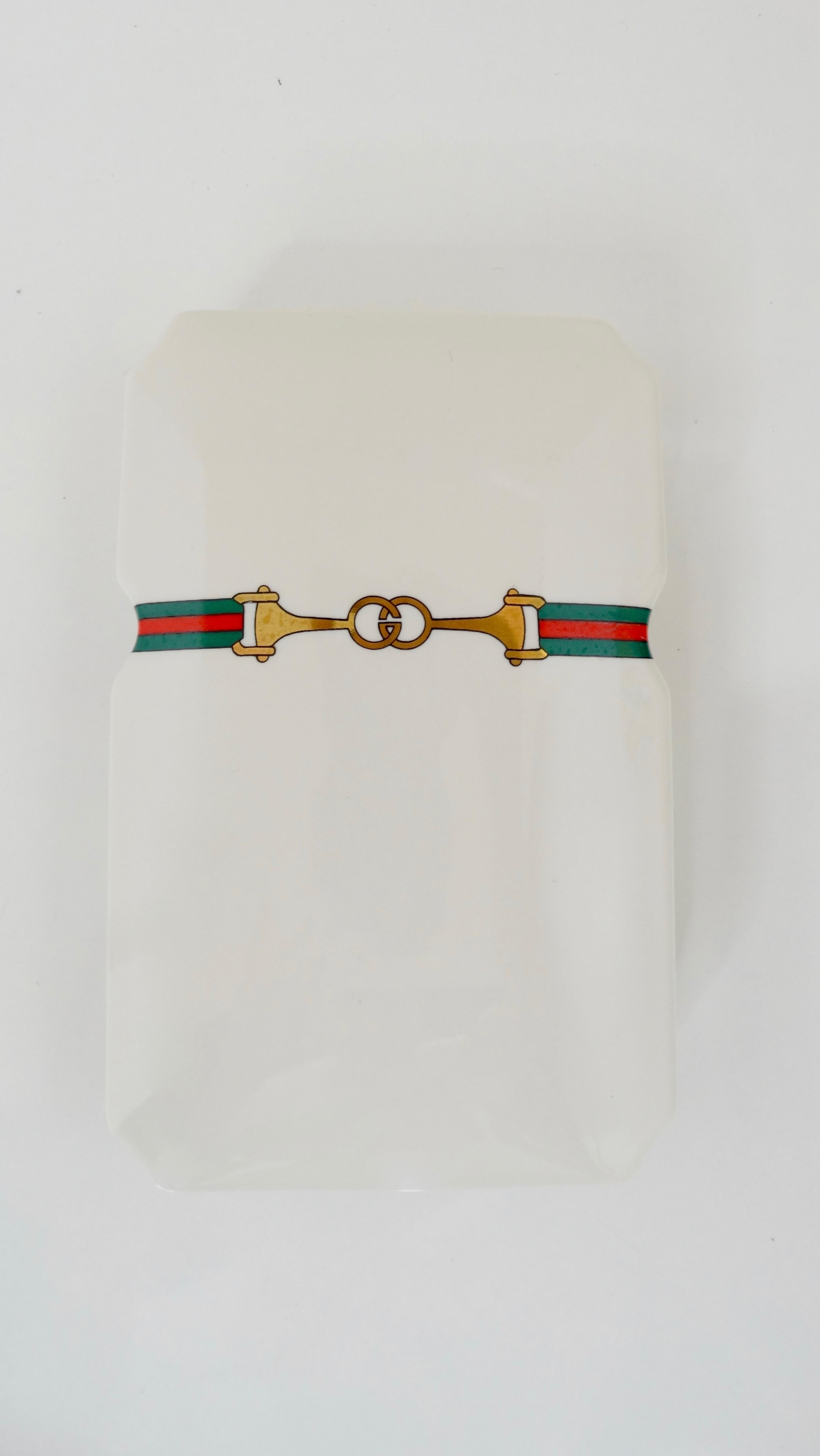 Spice up your space with this Gucci incense set! Circa 1980s, this two piece porcelain incense box features the iconic green and red Gucci horse bit logo on the front. Stored inside are red and green perfumed incense and a burner stand. The perfect