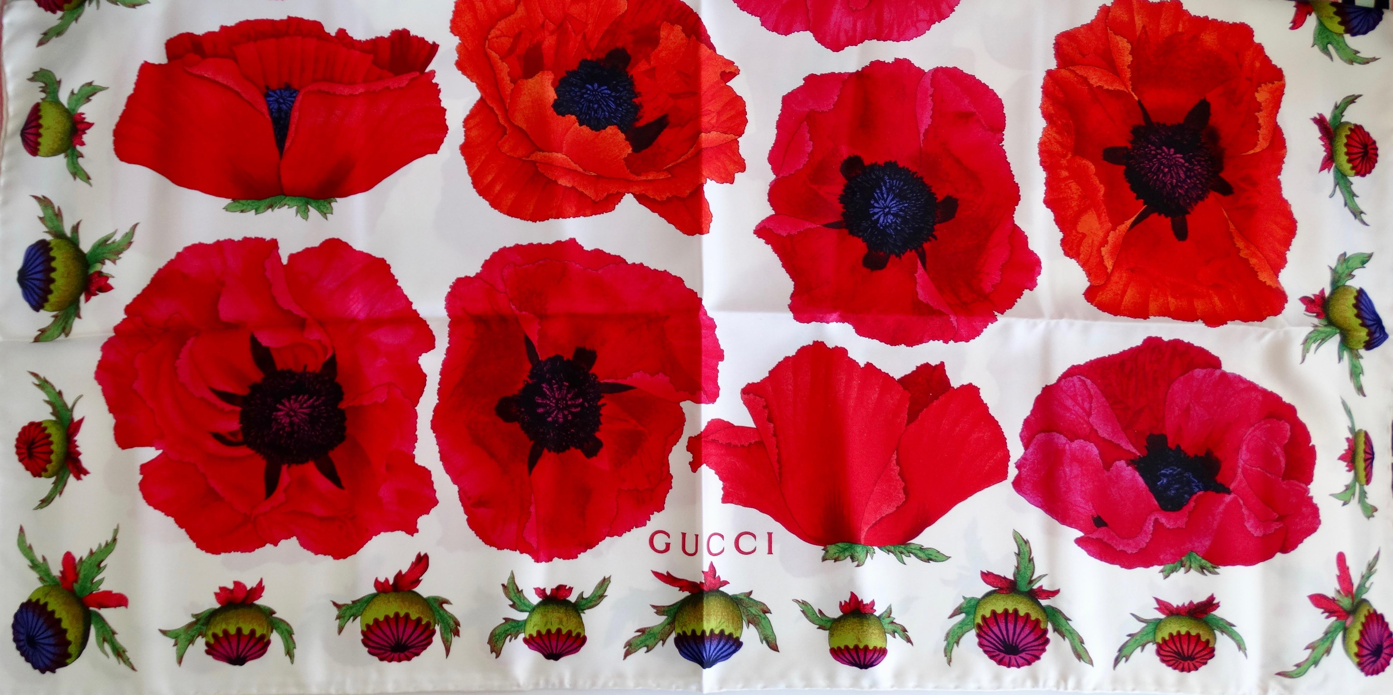 Everyone needs a vintage Gucci scarf in their collection! Circa 1980s, this Gucci silk scarf features a colorful poppy motif against a white background. Vibrant poppy buds line the trim and Gucci is featured in red lettering at the center bottom.