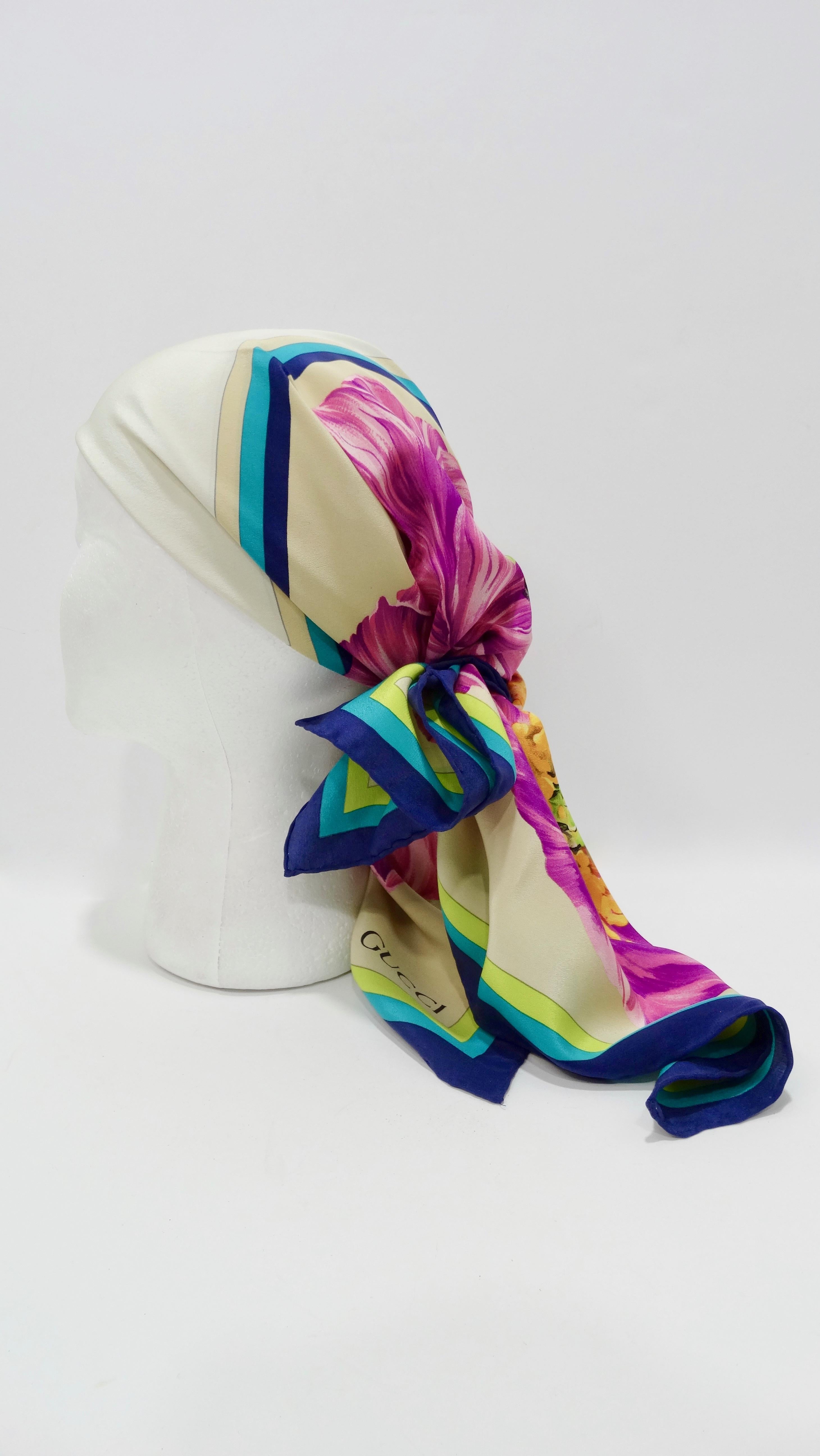 Elevate your looks with this amazing Gucci scarf! Circa 1980s, this silk scarf features a vibrant purple poppy motif with a blue and green boarder framing the center and outside trim. Rolled edges and has 