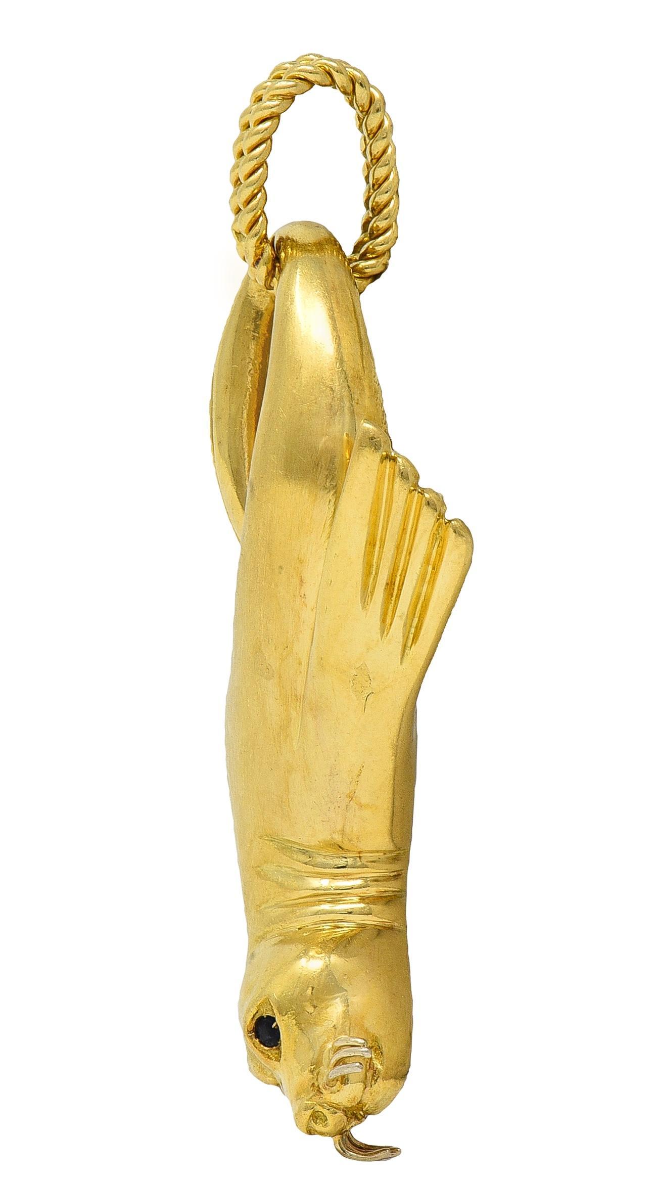 Designed as a highly rendered seal with dimensional features
With grooved flippers and face with white gold whiskers
Accented by round cut and bead set sapphire eyes
Weighing approximately 0.10 carat total - dark blue
Suspending from twisted rope