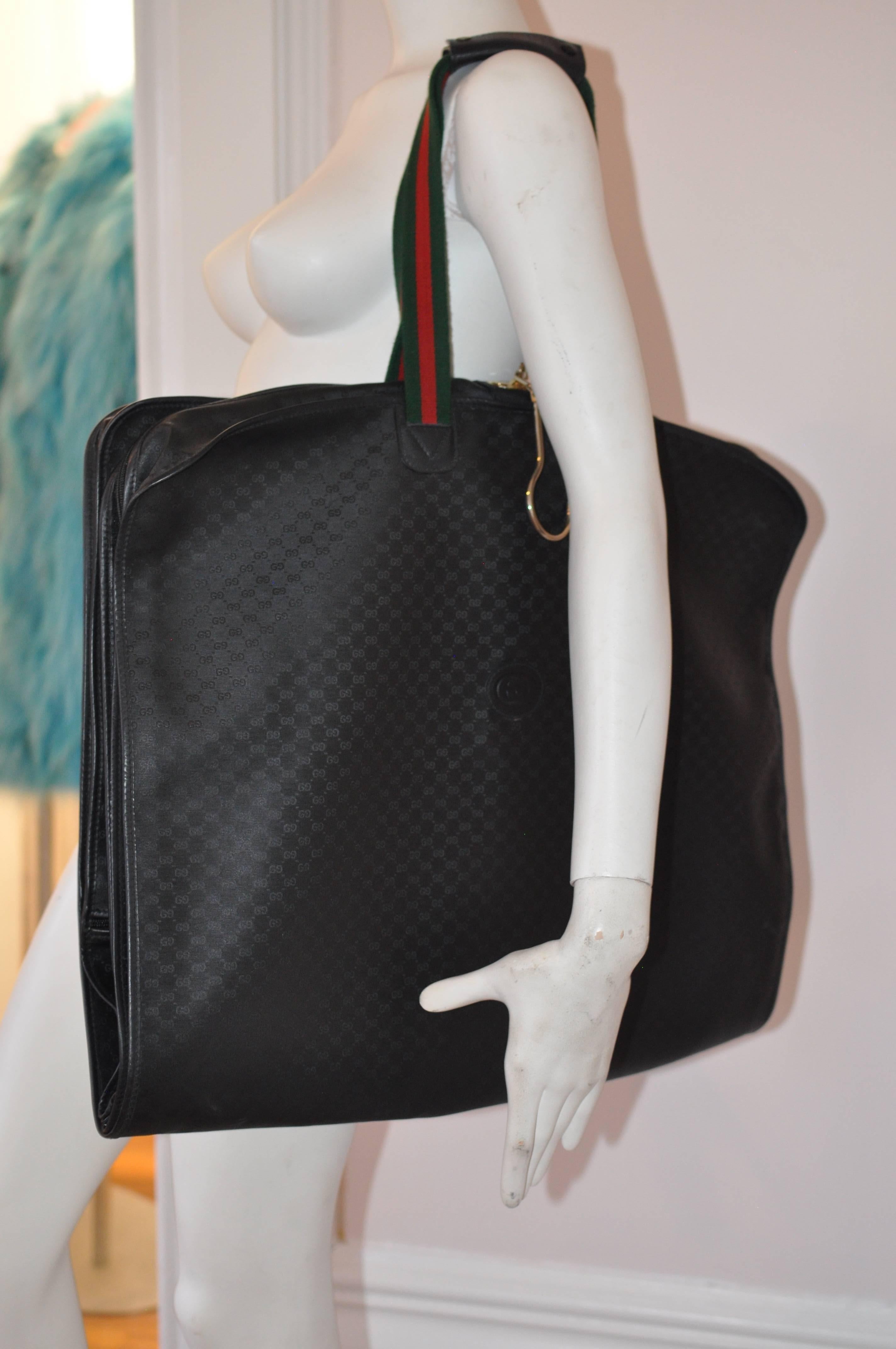 This black monogram garment bag has the red and green classic handle detail; zip around closures; front zipped compartment, and a built-in hanger system. The bag is in very good condition except for scratches on a very small area (pictured), and one