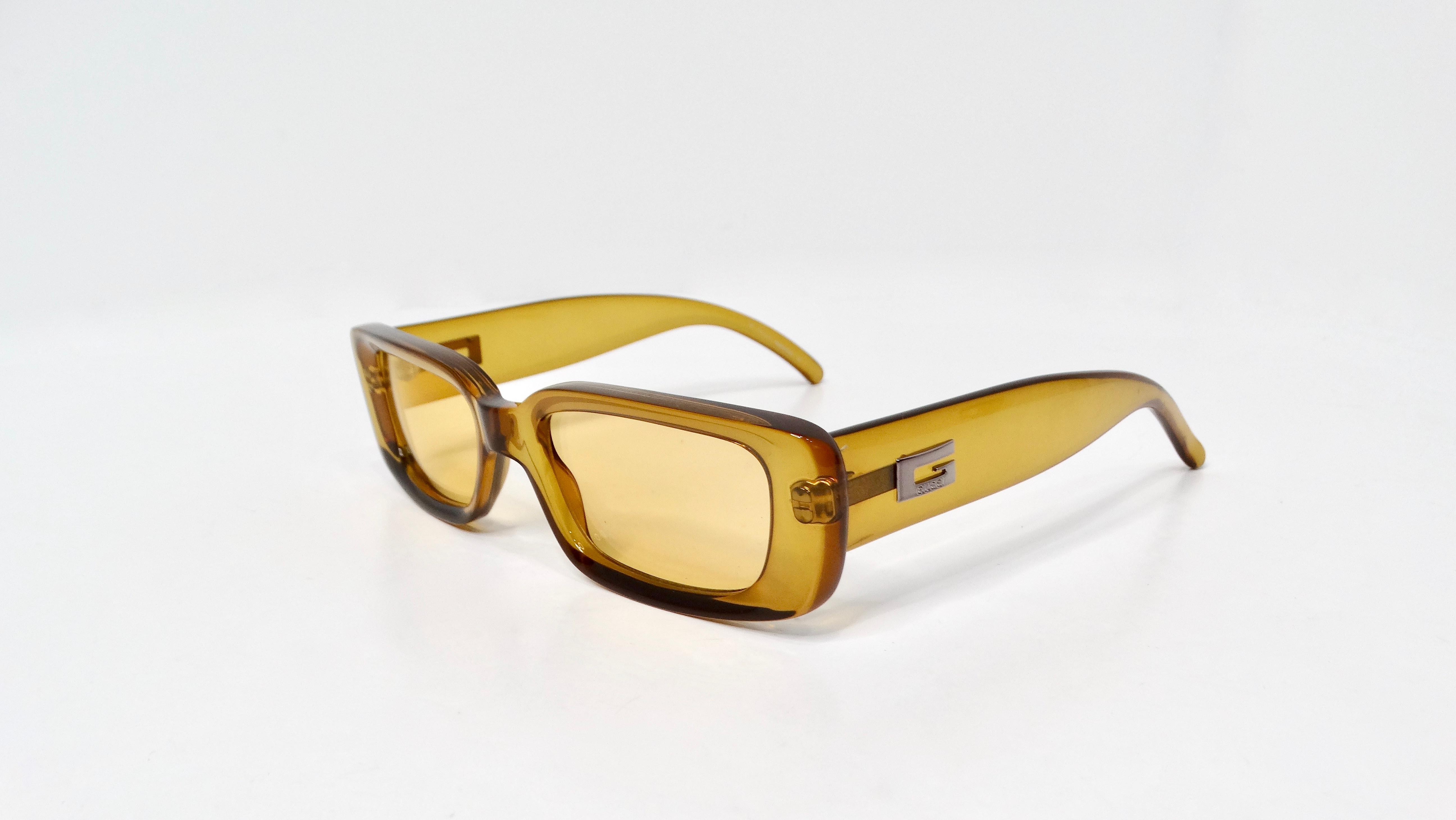 Gli occhiali da sole Gucci 1990s GG2409 sono un accessorio audace e giocoso che cattura l'essenza del lusso vintage. Con la loro straordinaria montatura rettangolare traslucida gialla, questi occhiali da sole sono una dichiarazione vivace e un look