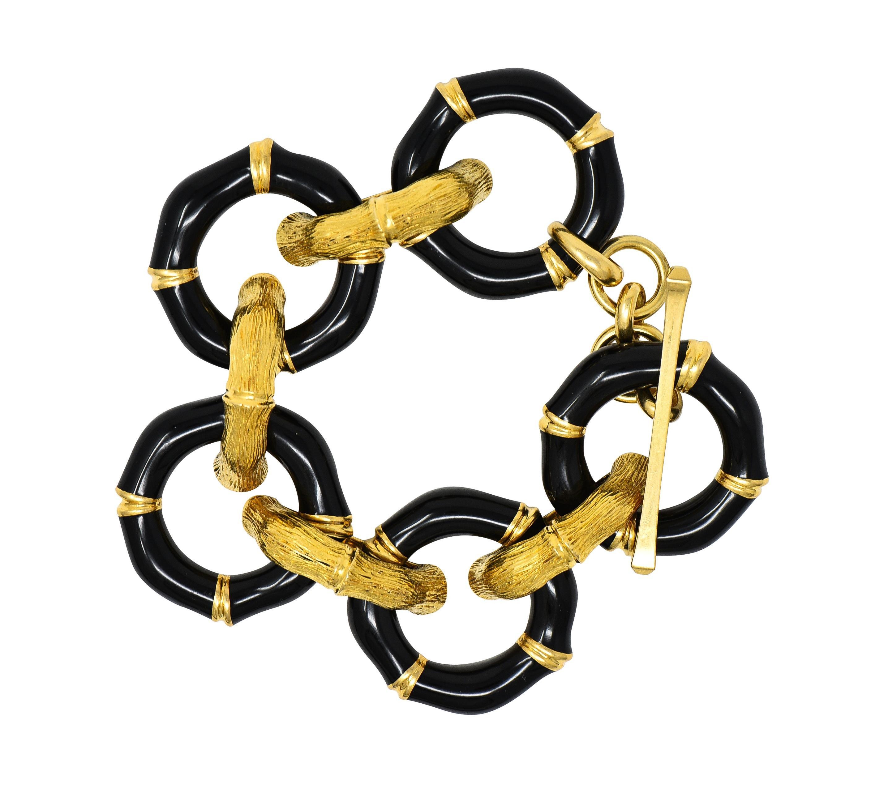 Comprised of alternating round and half-round grooved bamboo motif links
Round links are glossed with opaque black enamel - minimal loss 
Half-round links are engraved with an organic linear texture
Completed by cable link chain with large toggle