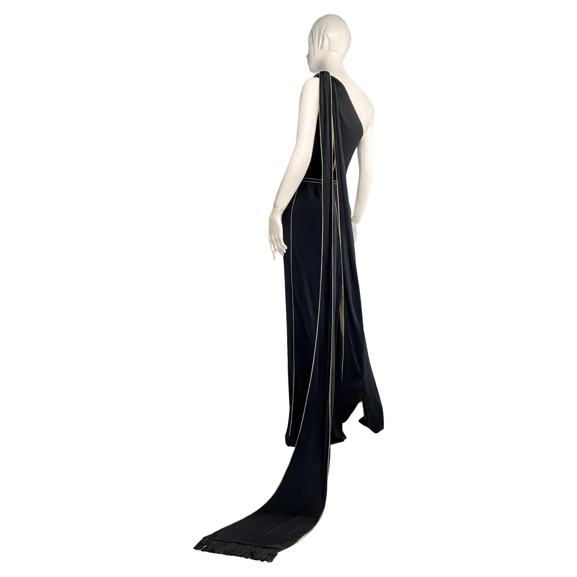 From 2006, this archival Gucci floor-length one-shoulder evening gown features asymmetric draped neckline, diagonal cutouts at front and back, and long fringed scarves/ties that we can style as a dress train, or tie in a bow, or wrap around