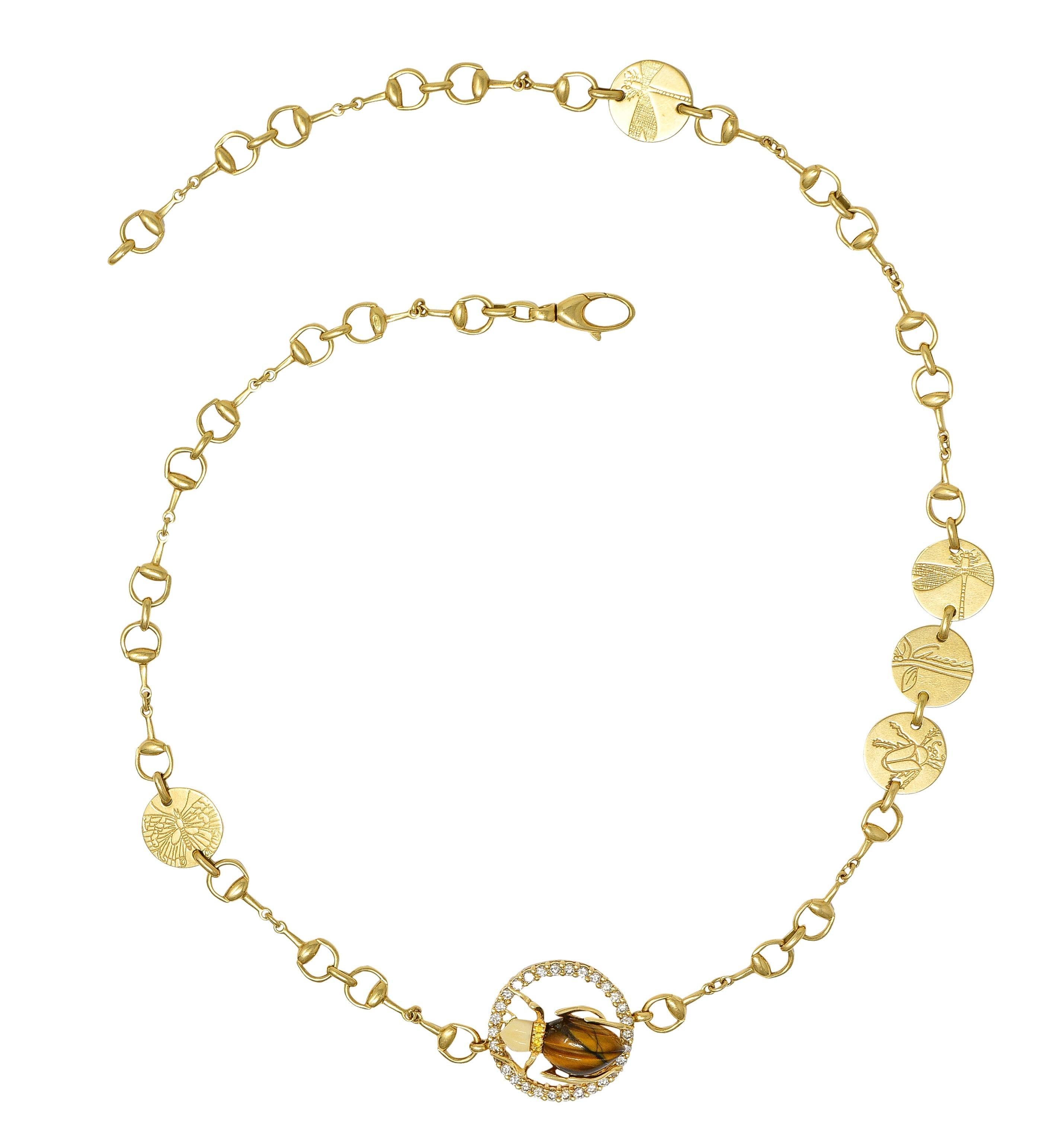Designed as a horse-bit motif link chain with round disk stations engraved with insects and flowers
Featuring a large pierced disk station centering a dimensional scarab beetle 
With body carved from tiger's eye quartz and head carved from