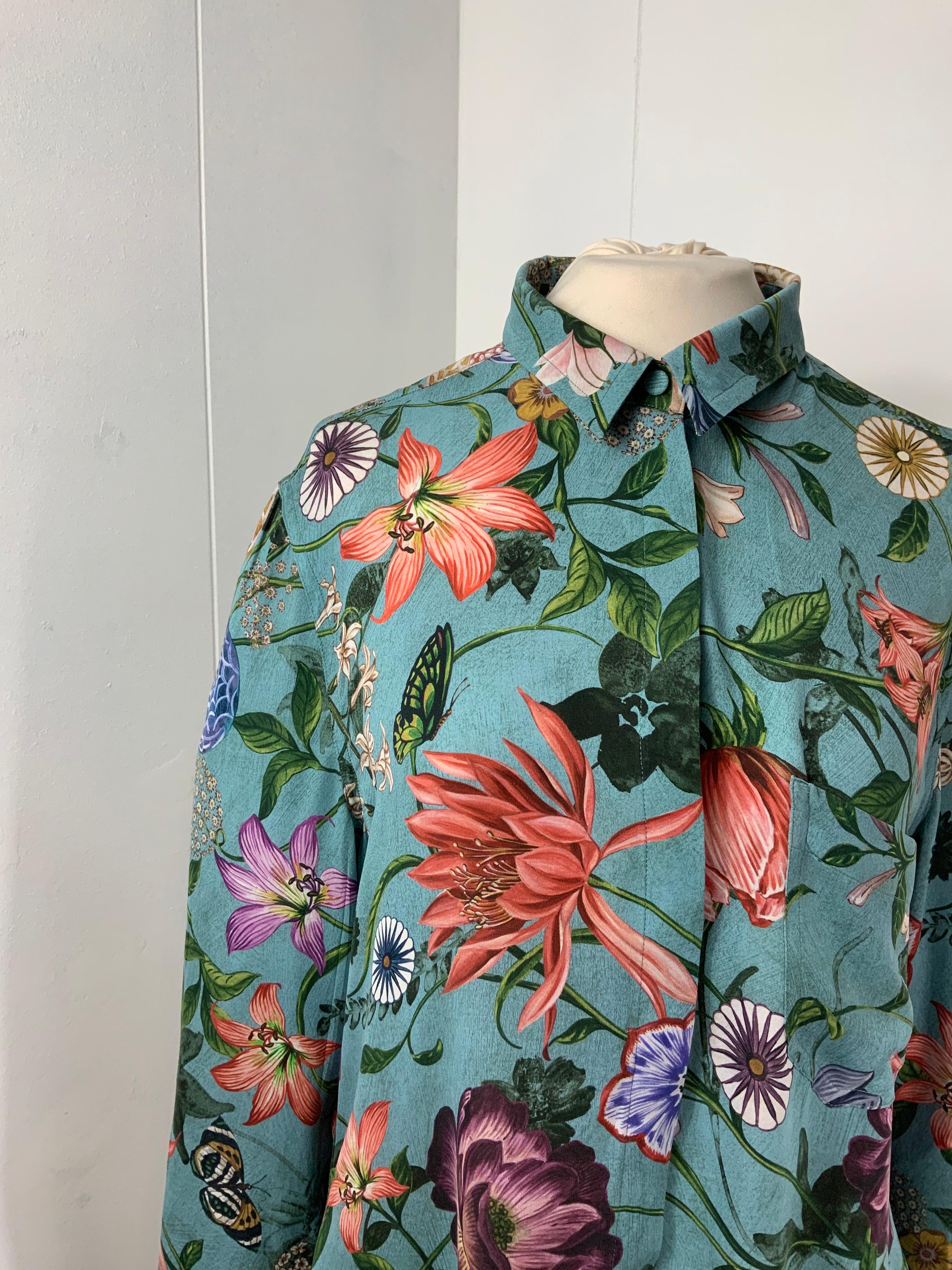 Gucci shirt 
Amazing Flora print.
100% silk.
Size 48 Italian 
Measurements 
Shoulders 46 cm
Bust 52 cm
Length 73 cm
Sleeves 60 cm
Conditions: Excellent - Previously owned, like new or lightly worn, with no signs of use and is in perfect condition.
