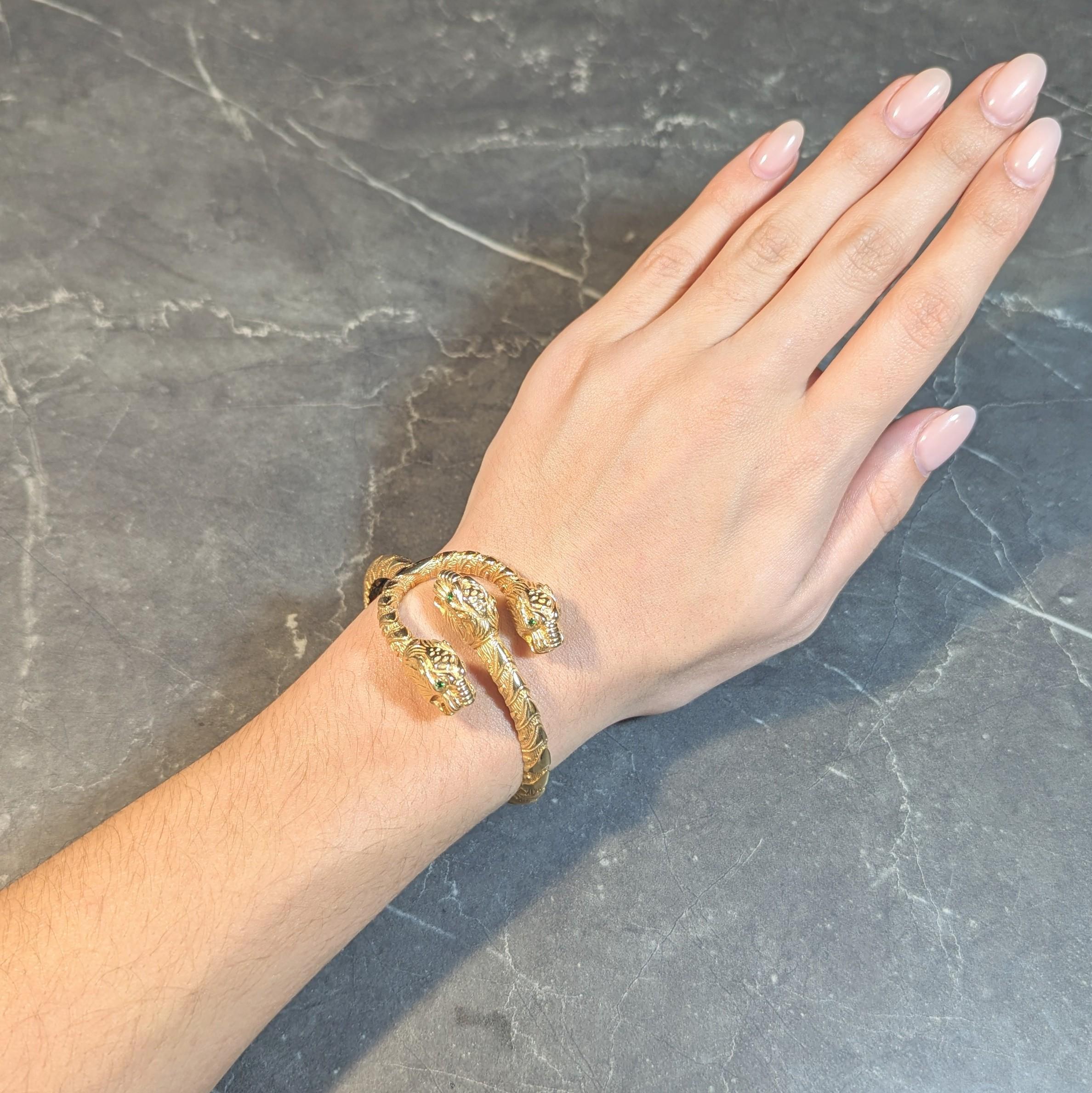 Un bracciale aperto che termina con tre teste di tigre stilizzate e una struttura a strisce scanalate.
Accentuato da occhi di granato tsavorite - taglio rotondo e misura 2.0 mm rotondo
Colore trasparente, verde brillante e vibrante e set di