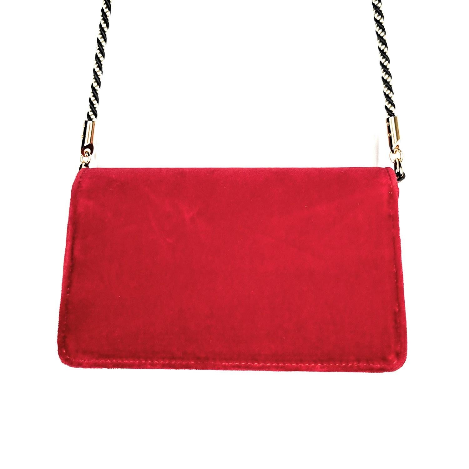 Red velvet Gucci Mini Broadway bag with multi-tonal hardware, single rolled shoulder strap with leather shoulder guard, pink satin lining and magnetic snap closure at front flap featuring crystal-embellished adornment. Retail price is
