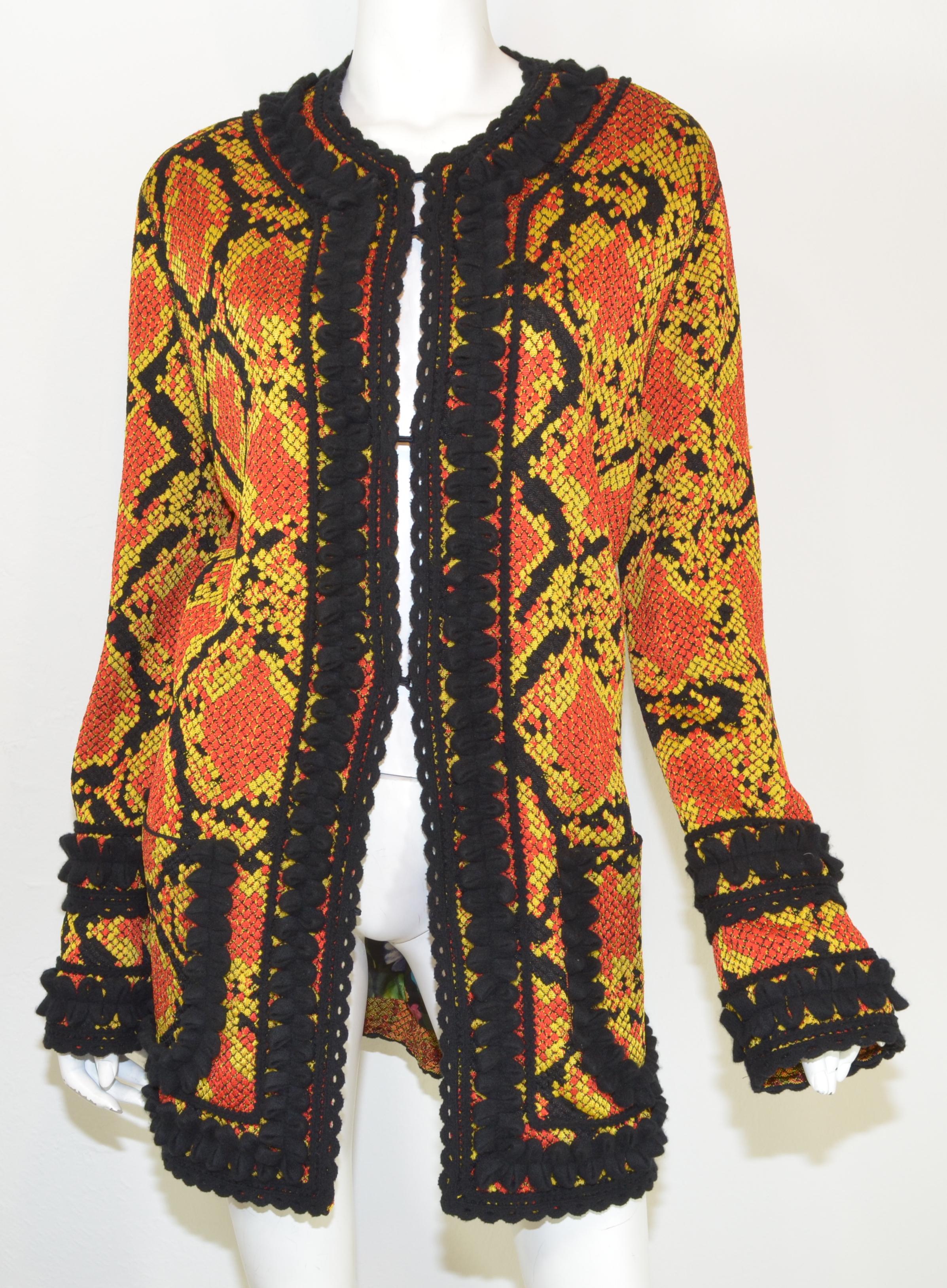 Gucci cardigan from their 2019 collection is featured in a red and yellow blend with a snakeskin design to the knitted fabric with hook-and-eye closures and a vibrant floral printed lining. Made in Italy. New with Tags with no flaws to
