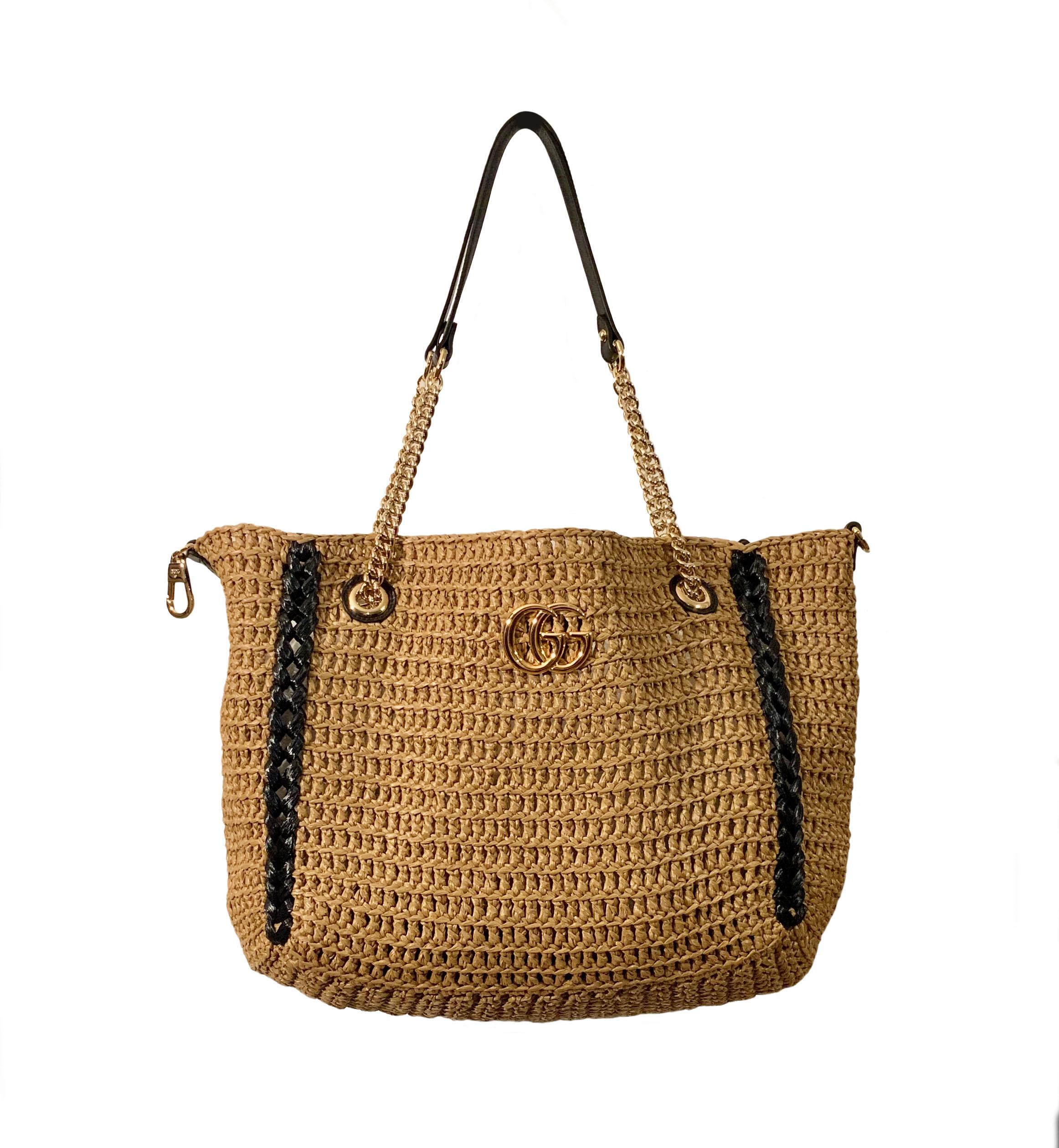 This new pre-owned Large GG Marmont Gucci tote bag is crafted of woven straw with a raffia effect. 
Black stripes running down on each side and the GG logo in the center.
It features two gold-tone chains with a leather handle as shoulder straps.