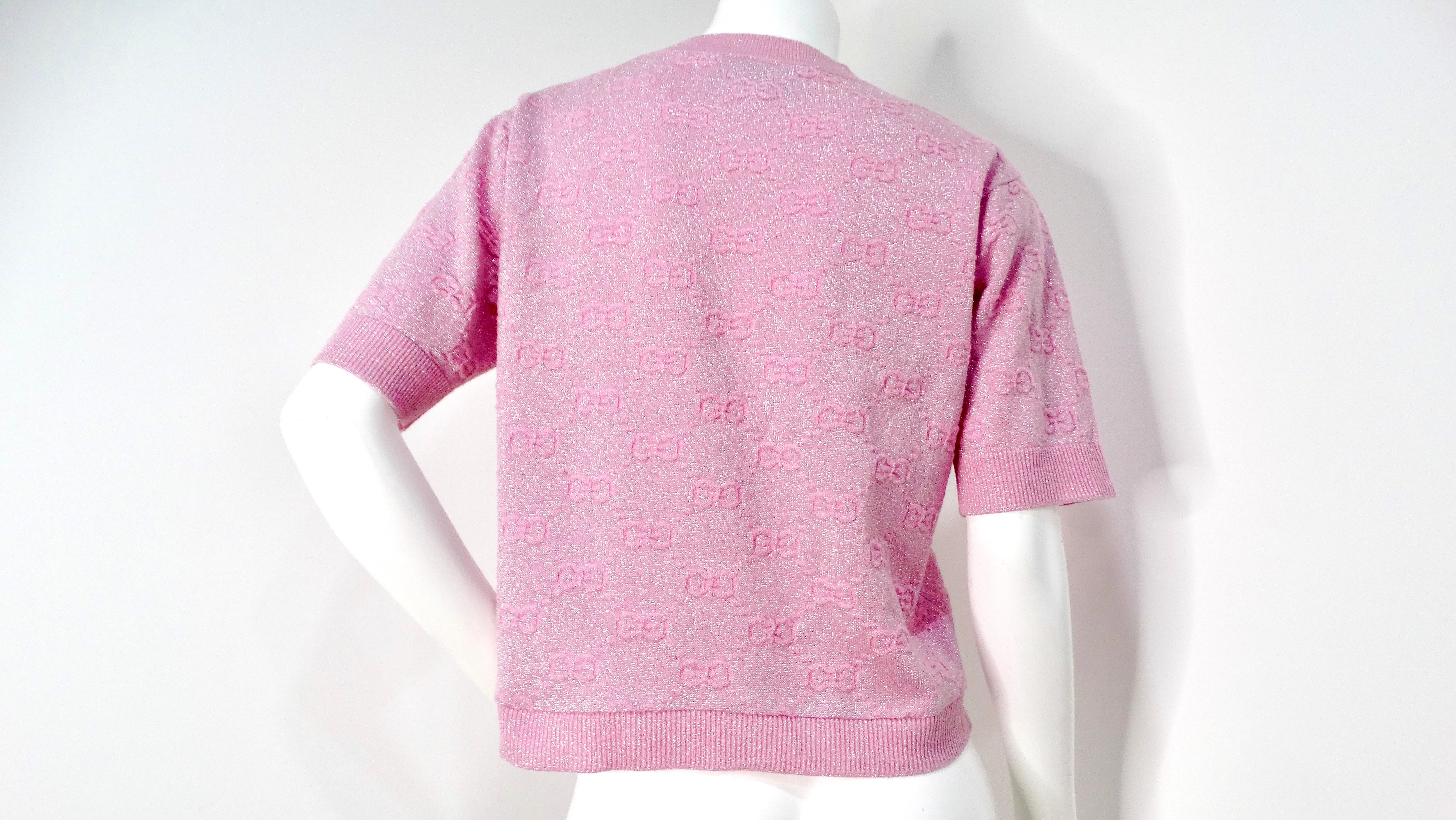 The Gucci 2020 Pink Shiny Wool Monogram T-Shirt is a stunning addition to any fashion-forward wardrobe. Rendered in a light purplish-pink hue, this t-shirt boasts a luxurious shine that catches the eye, while the embroidered Gucci monogram pattern