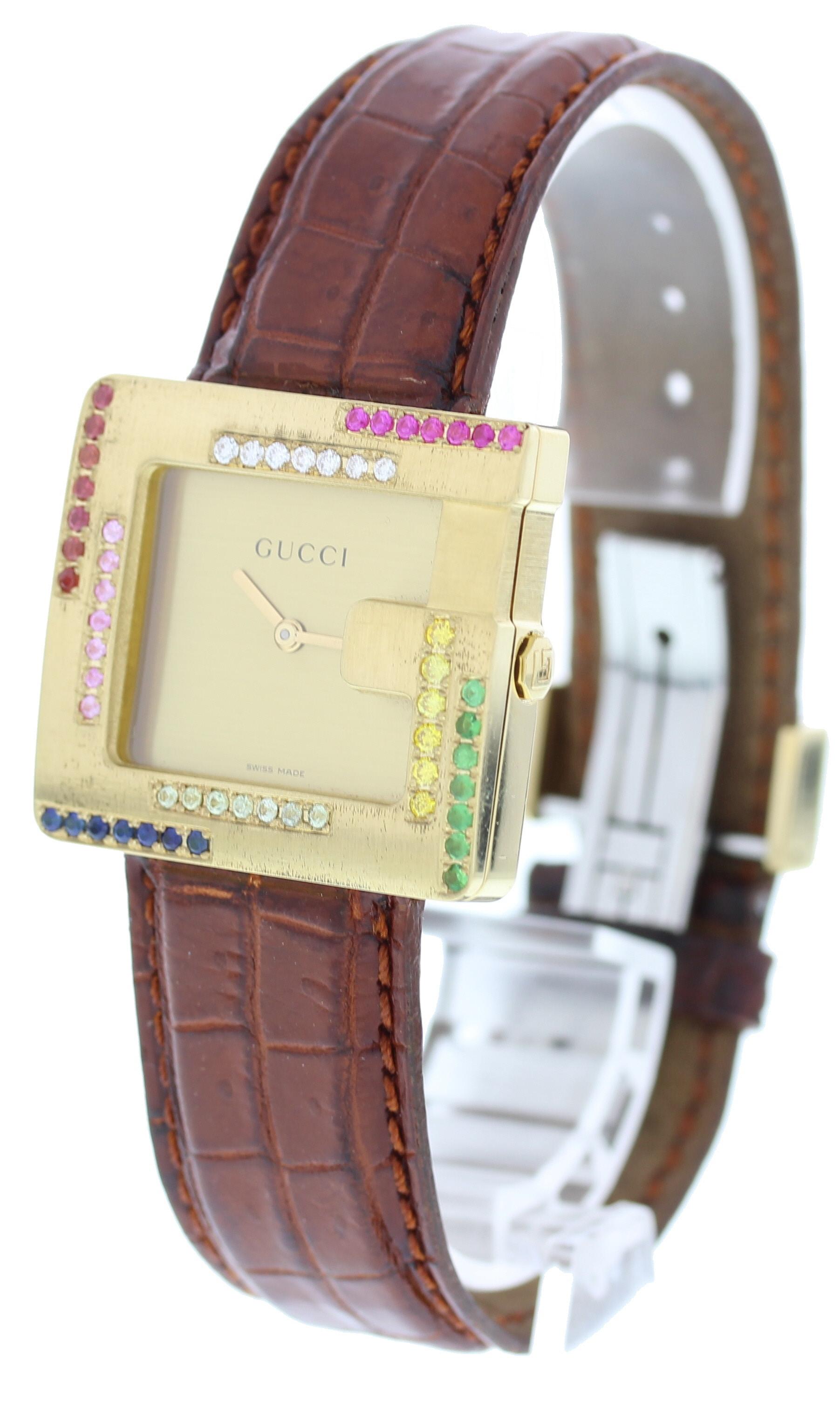 Gucci 3600M. 31mm 18k gold case with custom set Diamonds and gems on bezel. Dark brown leather strap with hidden butterfly clasp. Water resistant. Sapphire crystal glass. Quartz movement. 

