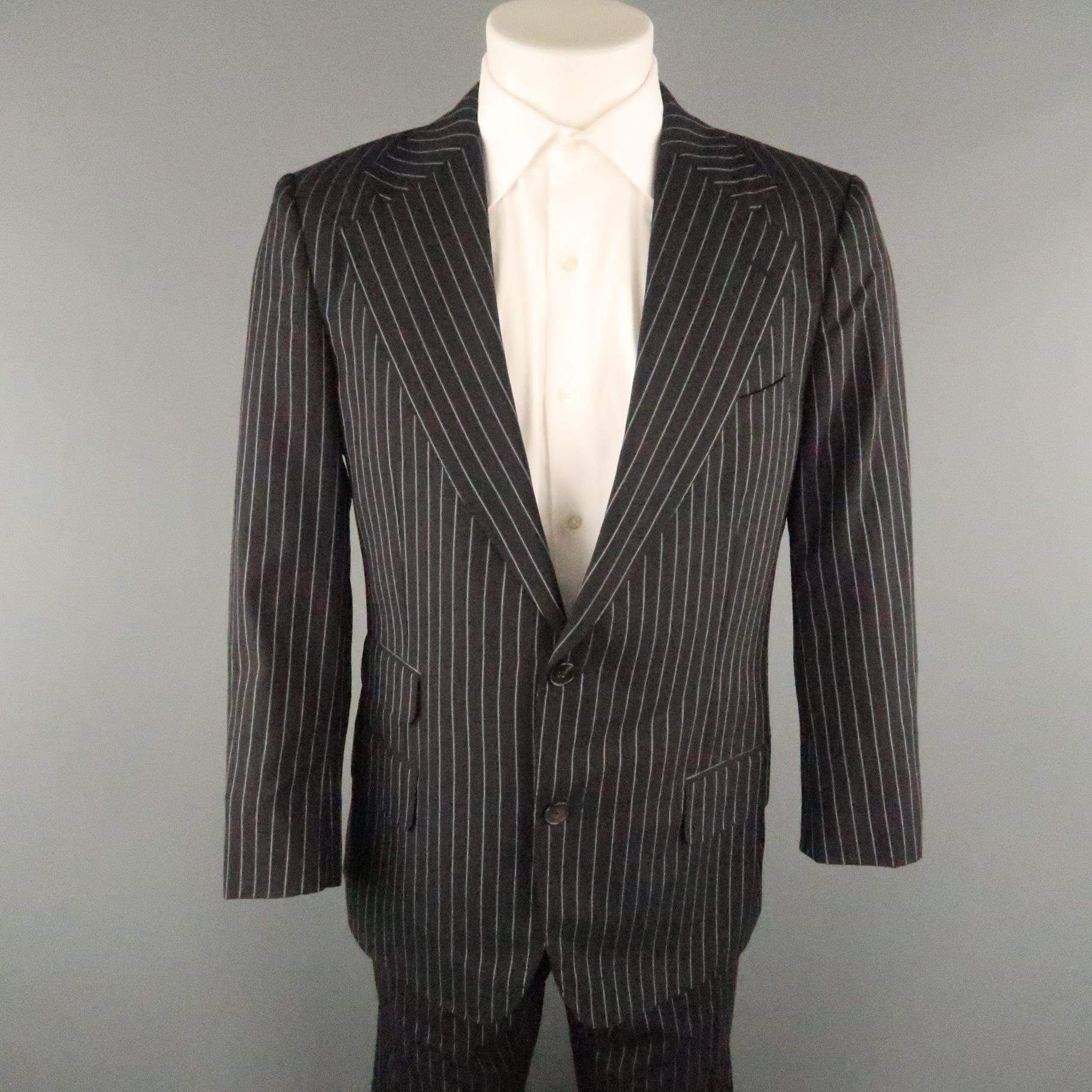 GUCCI suit comes in a black and white pinstripe wool featuring a notch lapel, single breasted, flap pockets, two button closure, and a matching flat front style pant.
 
Excellent Pre-Owned Condition.
Marked: 52
 
Measurements:
 
-Jacket
Shoulder: 18