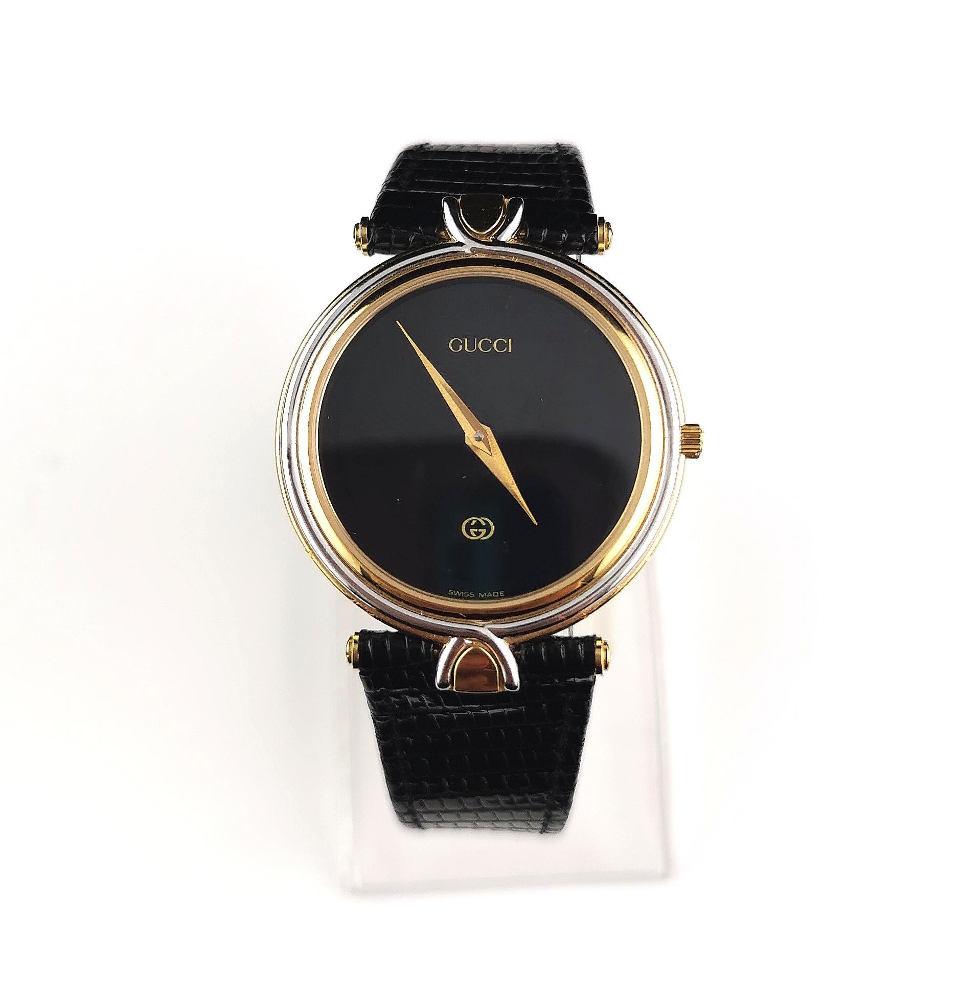 A stylish Gucci 4500M stainless steel and gold plated wristwatch.

This is a strap watch originally from the mens range but it will work for men or women, it has a large circular face with a black dial and gold lettering and logo, no numerals.

The