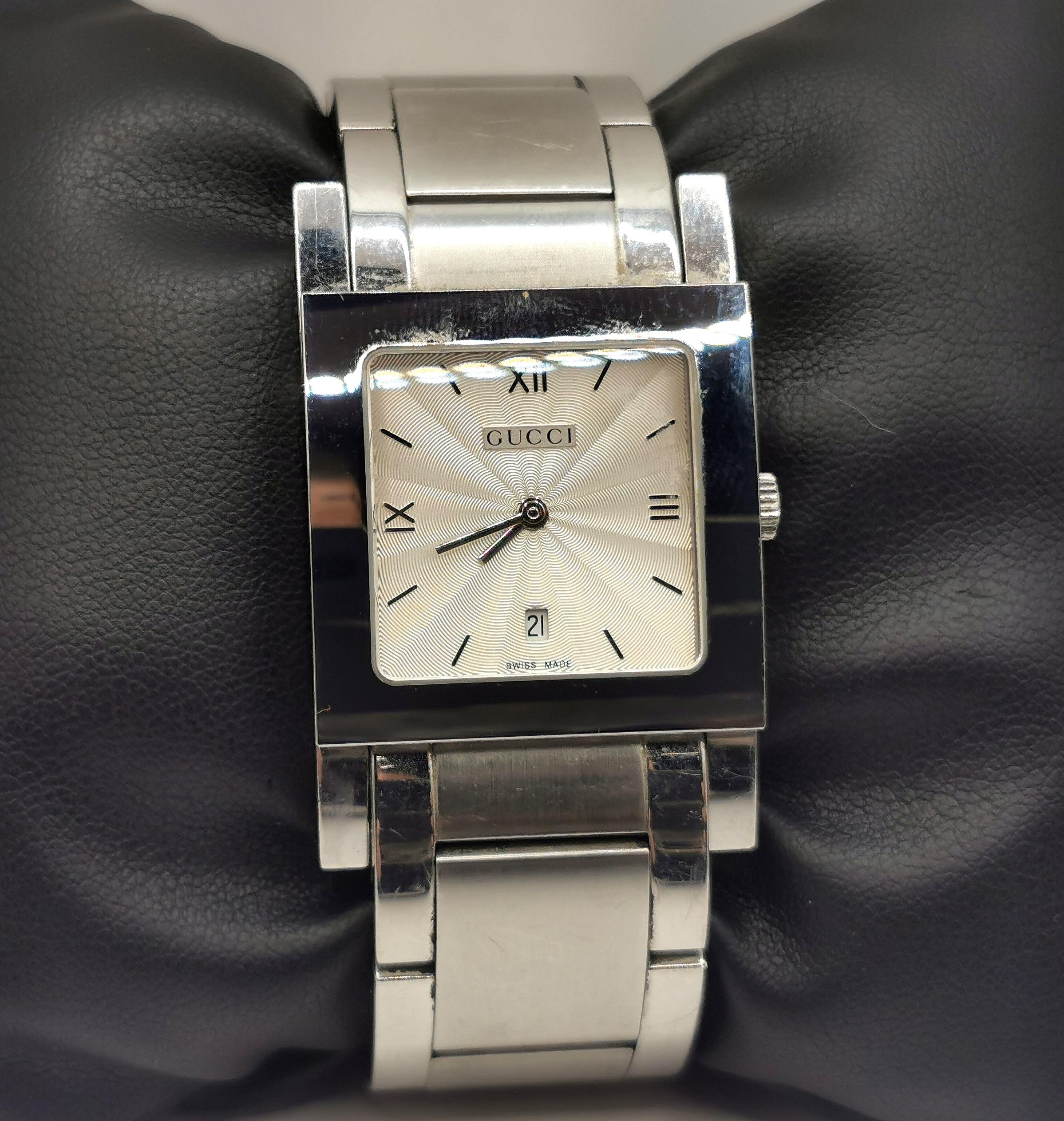 A stylish Gucci 7900M.1 stainless steel watch.

This is a bracelet strap watch with a nice chunky stainless steel bracelet.

The case is stainless steel with a champagne silver dial, silver hands and black logo with roman numerals, the watch has a