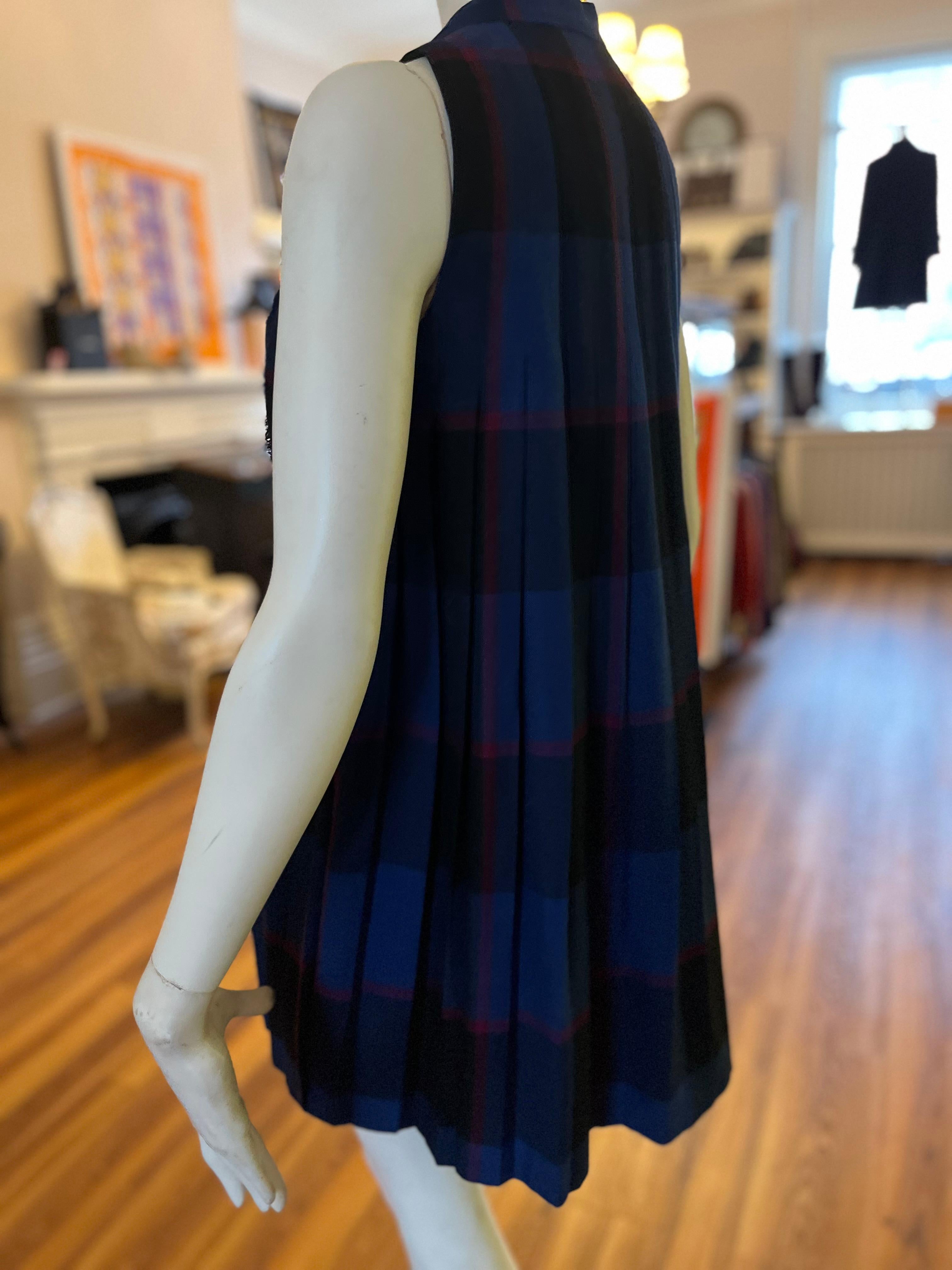 This dress is part of Gucci's A/W 2008 collection. This lovely piece has semi-wrap features with snap button closures, as well as leather and silver-tone adjustable mini belts.
The material is 70% wool  and 30% silk with a silk lining The dress is