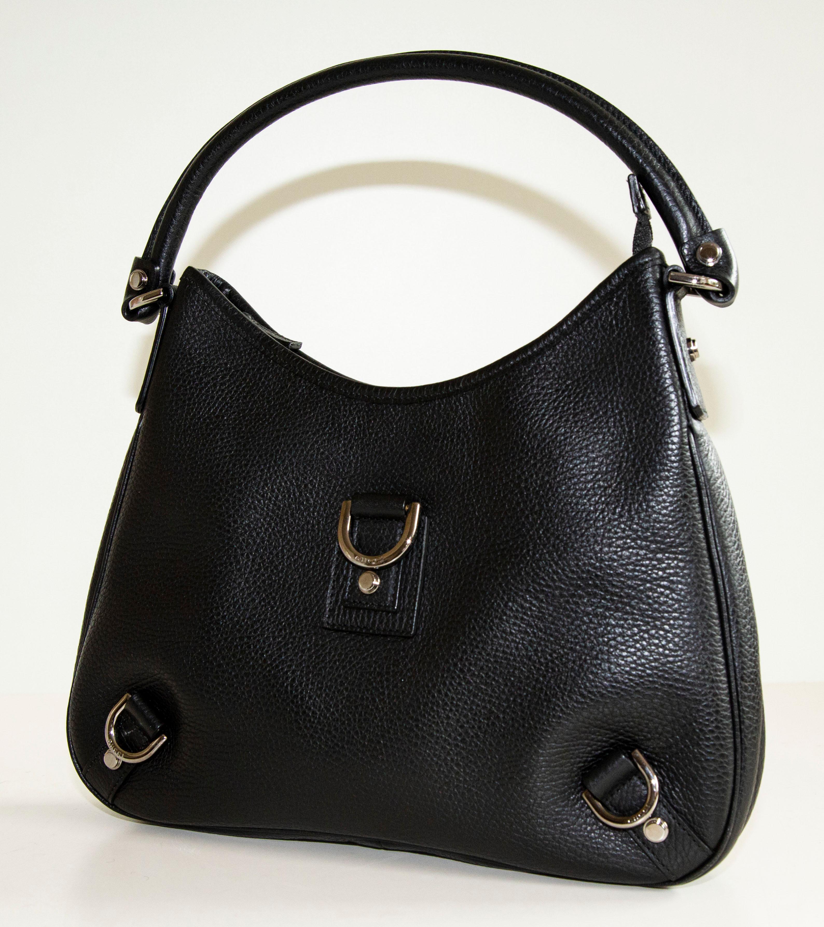 Un authentique sac à bandoulière Gucci Abbey D-Ring. Le sac est doté d'un extérieur en cuir noir et d'une quincaillerie de couleur argentée. L'intérieur est doublé de tissu noir et comporte deux poches latérales :  une pochette et une pochette