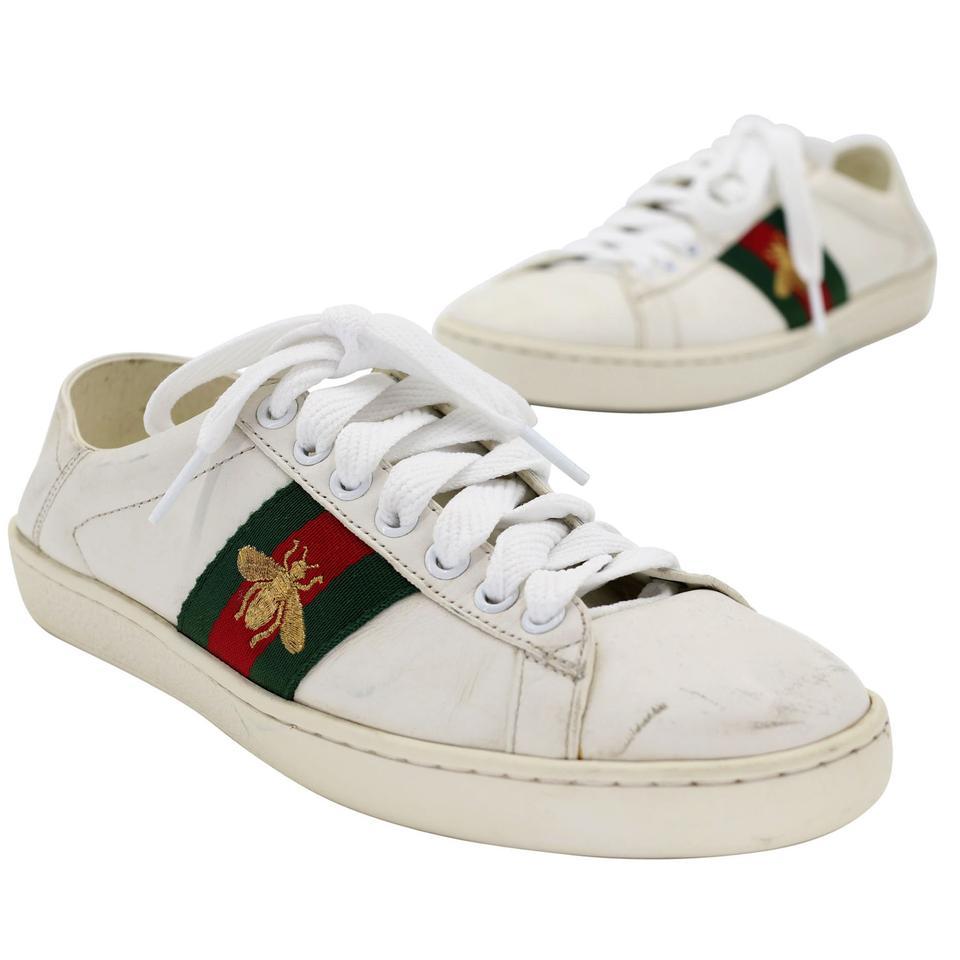 These stylish sneakers are crafted of leather and embellished with the iconic Gucci Bee green and red web canvas red and green snakeskin at the heels. These are fabulous eye-catching sneakers for a classic look. Shoes are in good condition, there