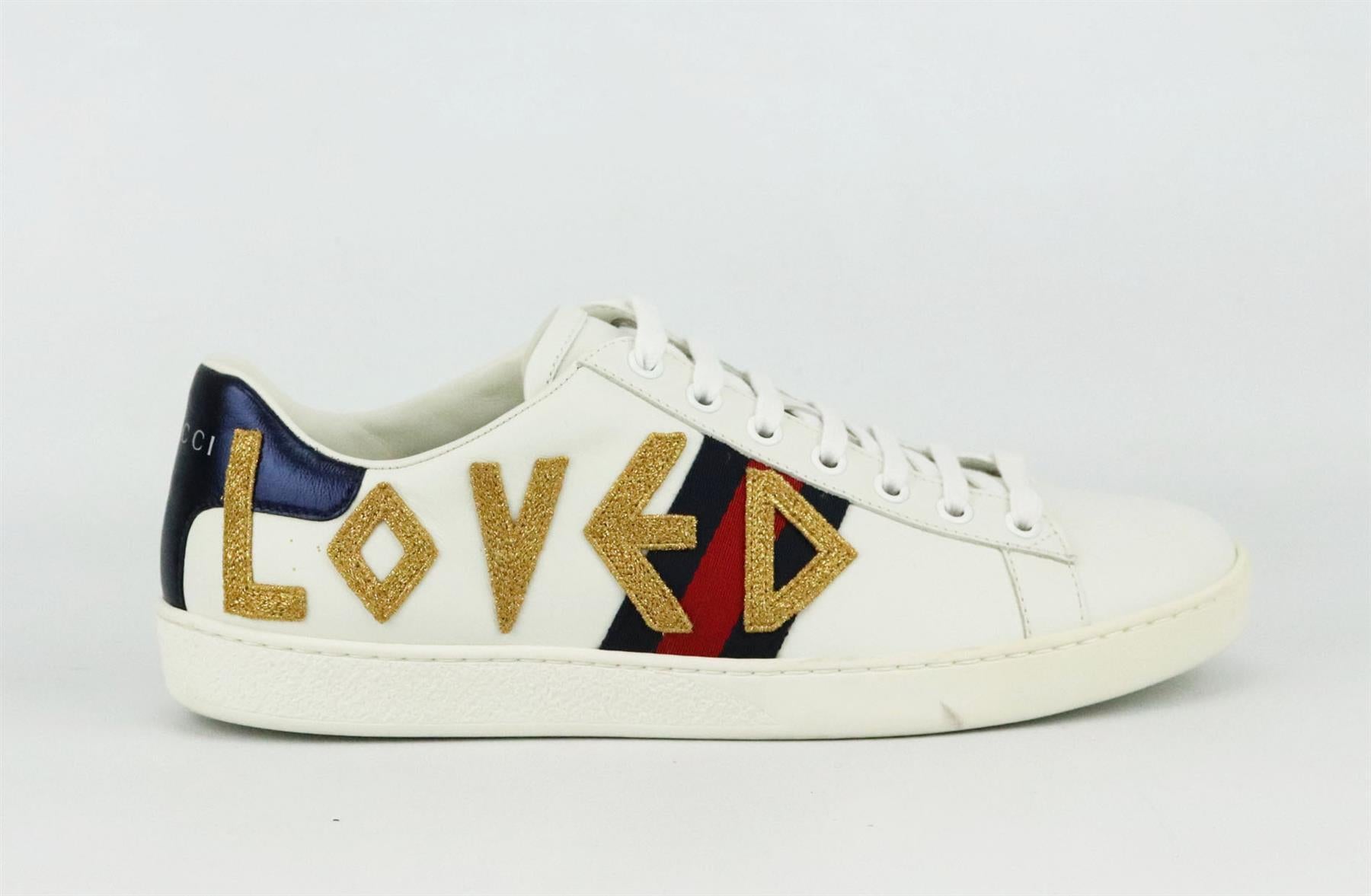 These 'Ace' sneakers by Gucci are a cool, sporty take on the now iconic style, made in Italy from pristine white leather, they have the instantly recognizable navy and red webbing that's embroidered with a LOVED in gold down the sides. 
Rubber sole