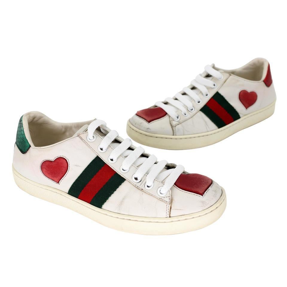 These stylish sneakers are crafted of soft leather and embellished with the iconic Gucci green and red web canvas with multicolored embroidered heart detail at the sides and metallic red and green snakeskin at the heels. These are fabulous