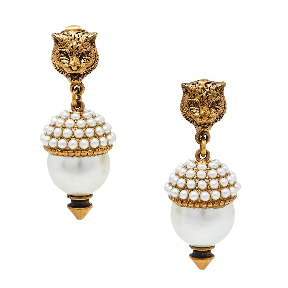 These Gucci earrings feature aged gold-tone metal, feline motifs, resin beads, and faux pearls to project a mesmerizing end result. Designed in a dangle style, they are eye-catching and comfortable. The perfect gift for a jewelry lover or the