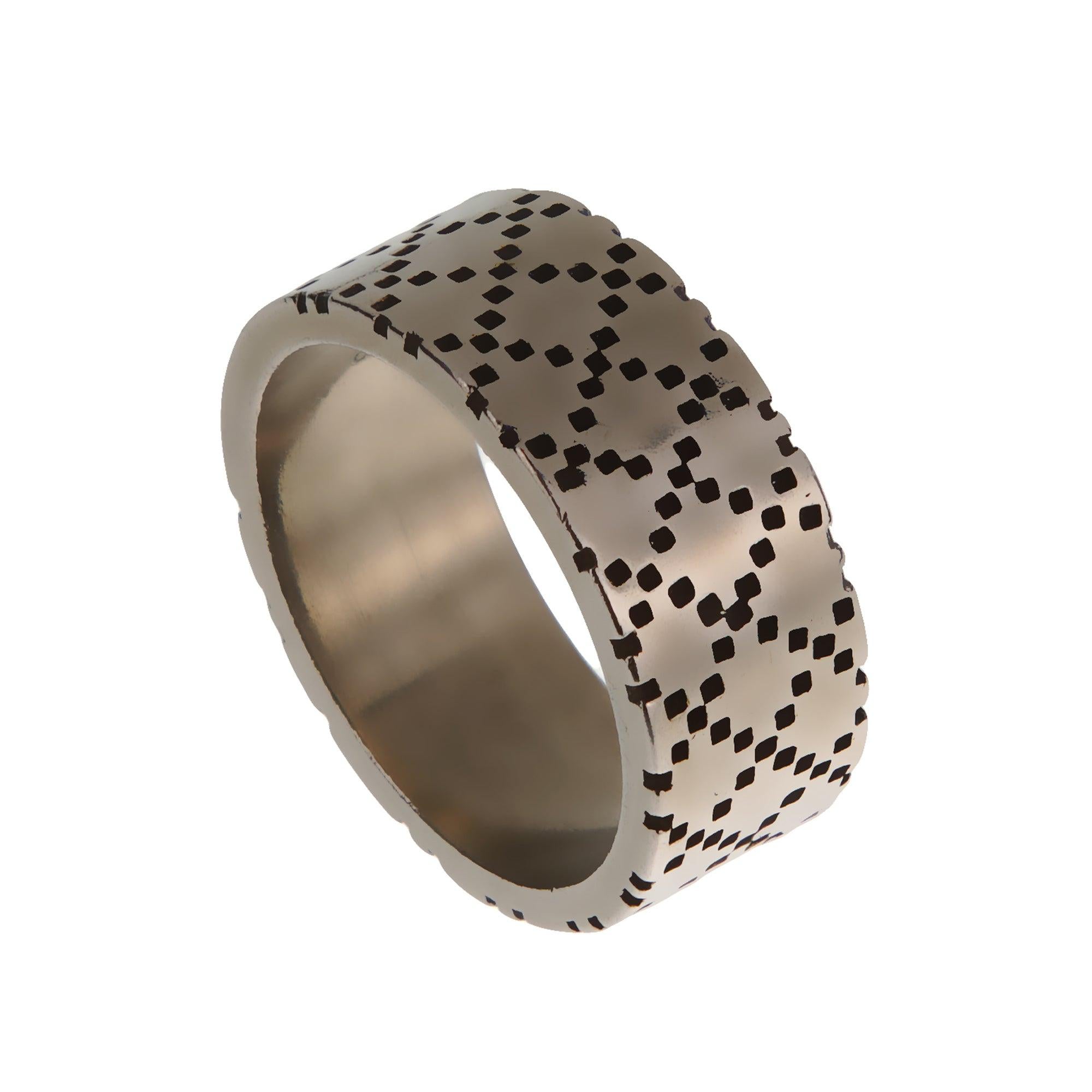 Un'audace fusione di fascino vintage e modernità.

Questo sorprendente anello Gucci affascina con la sua fascia larga, realizzata in argento massiccio 925 invecchiato, che emana un fascino robusto e industriale. Il motivo pixelato inciso sul