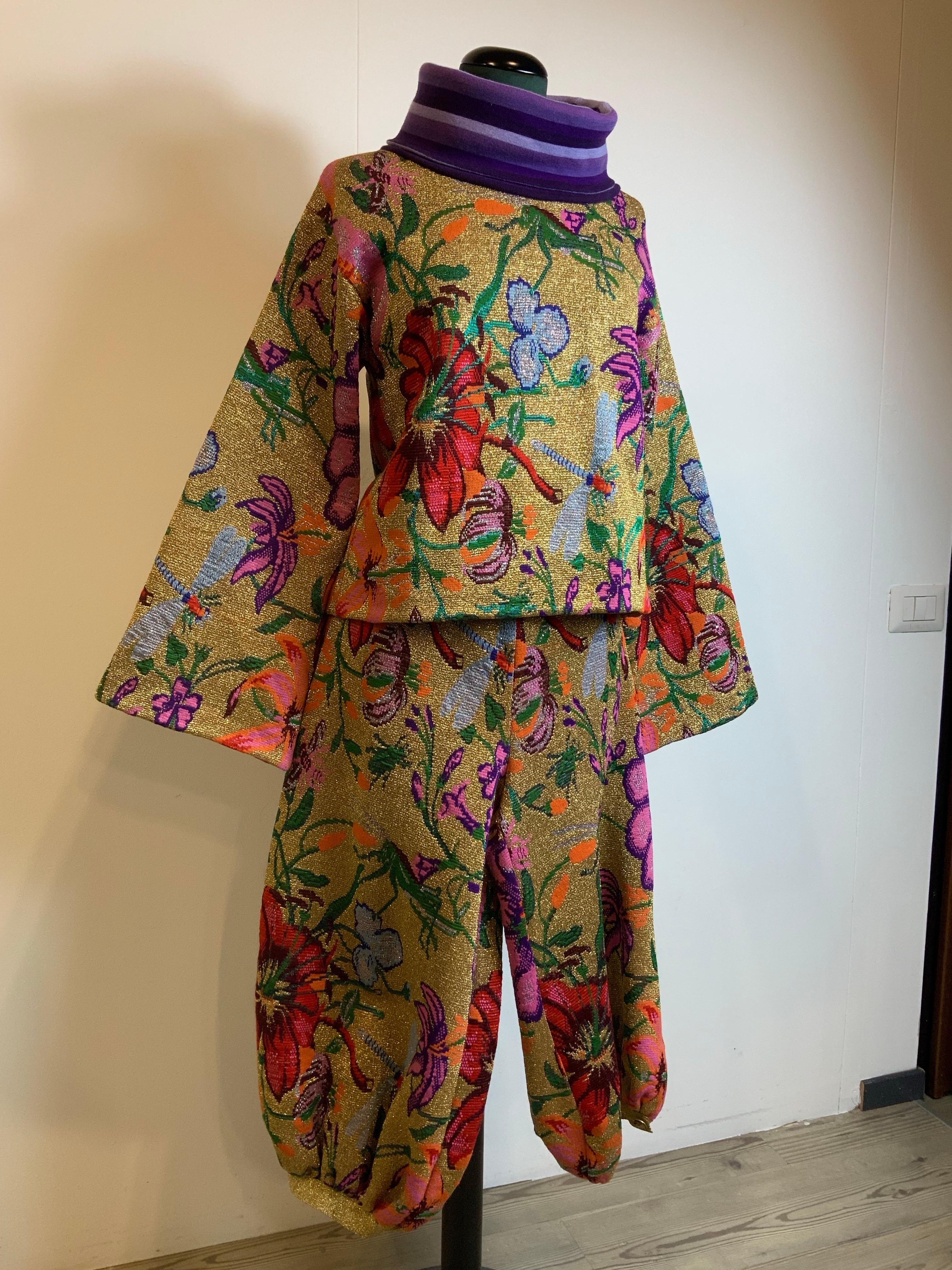 L'ensemble di Gucci.
Mancano l'etichetta della composizione e della taglia.
Pensiamo che sia un misto lana. Fantasia floreale.
Indossa una M. I. internazionale.
Capispalla:
Spalle 50 cm
Buste da 50 cm
Lunghezza 55 cm
Pantaloni:
Vita 39 cm
Lunghezza