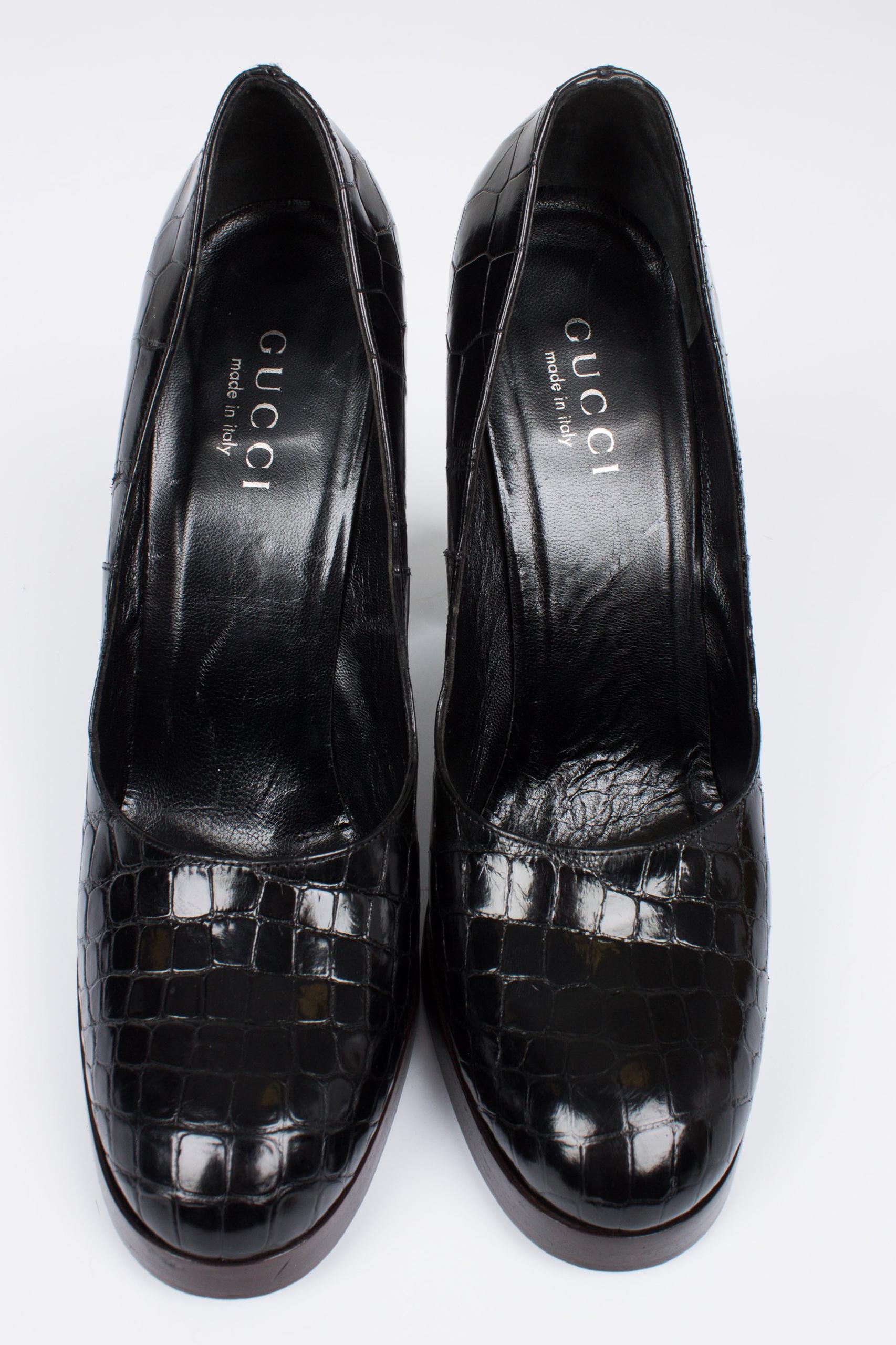 Very shiny black croco pumps by Gucci, neat and classy!

This pair is new and never worn, the alligator leather and sole are impeccable. The dark brown heel measures 12 centimeters, platform 1,5 centimeters. Fully lined with black leather. Silver