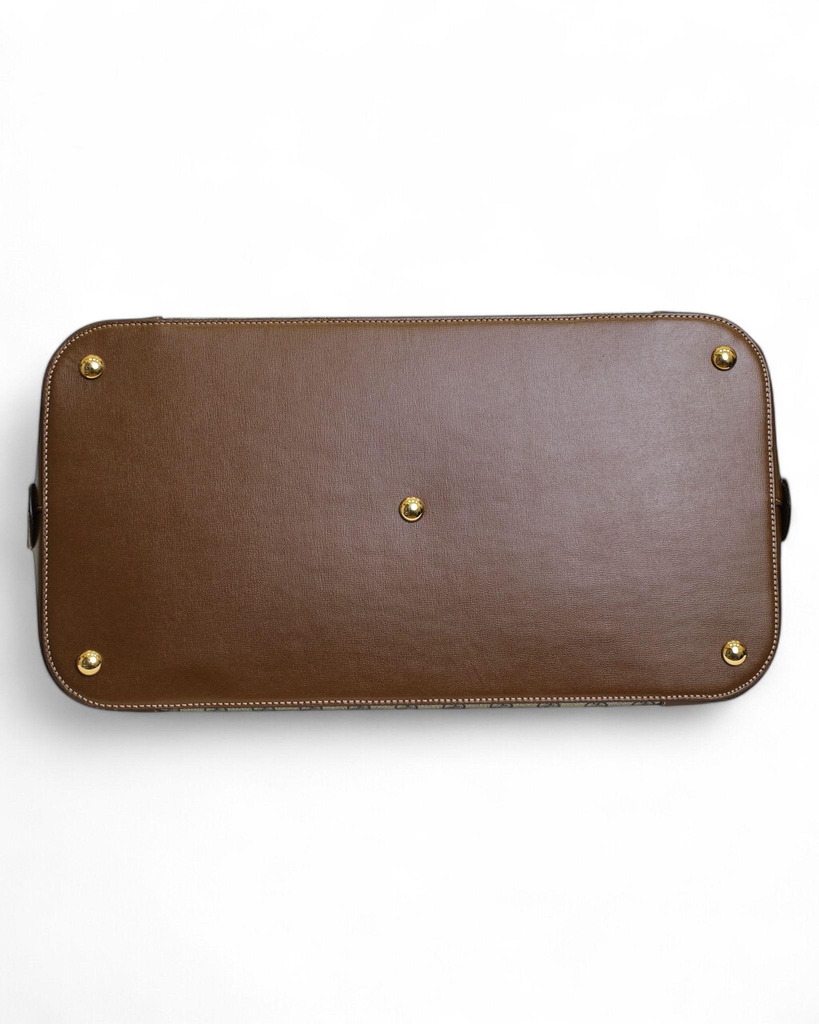 Gucci signature travel bag, Supreme line, Alma model in size Large. Made of beige canvas with the classic GG Supreme pattern, enhanced by brown leather inserts and gold hardware details. Semi-circular double-slider zipper closure provides security