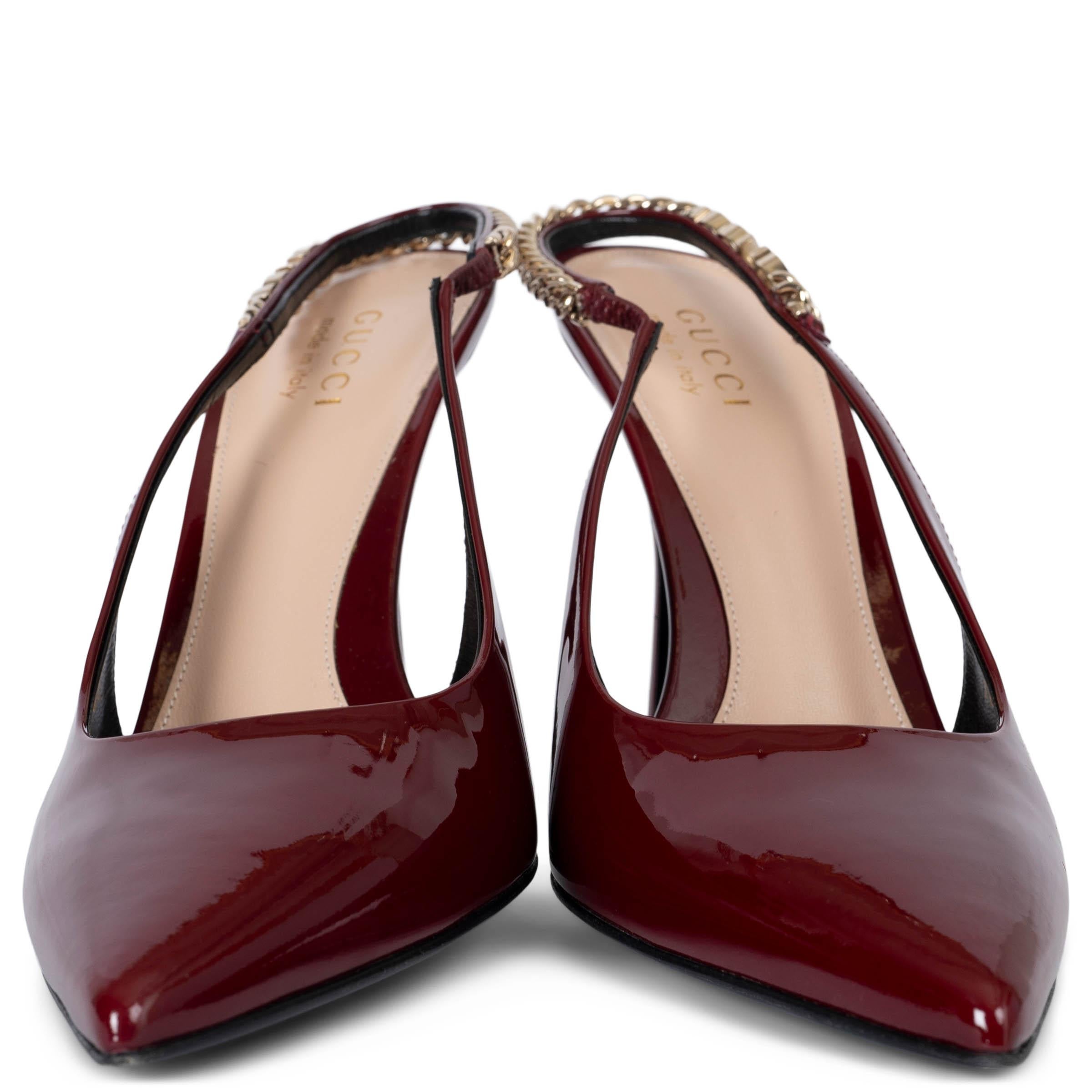 These 100% authentic Gucci Signora slingbacks in Rosso Ancora burgundy patent leather exude elegance and sophistication. They feature a gold-tone chain and logo detail on the straps, pointed toes, and high stiletto heels, making them a striking