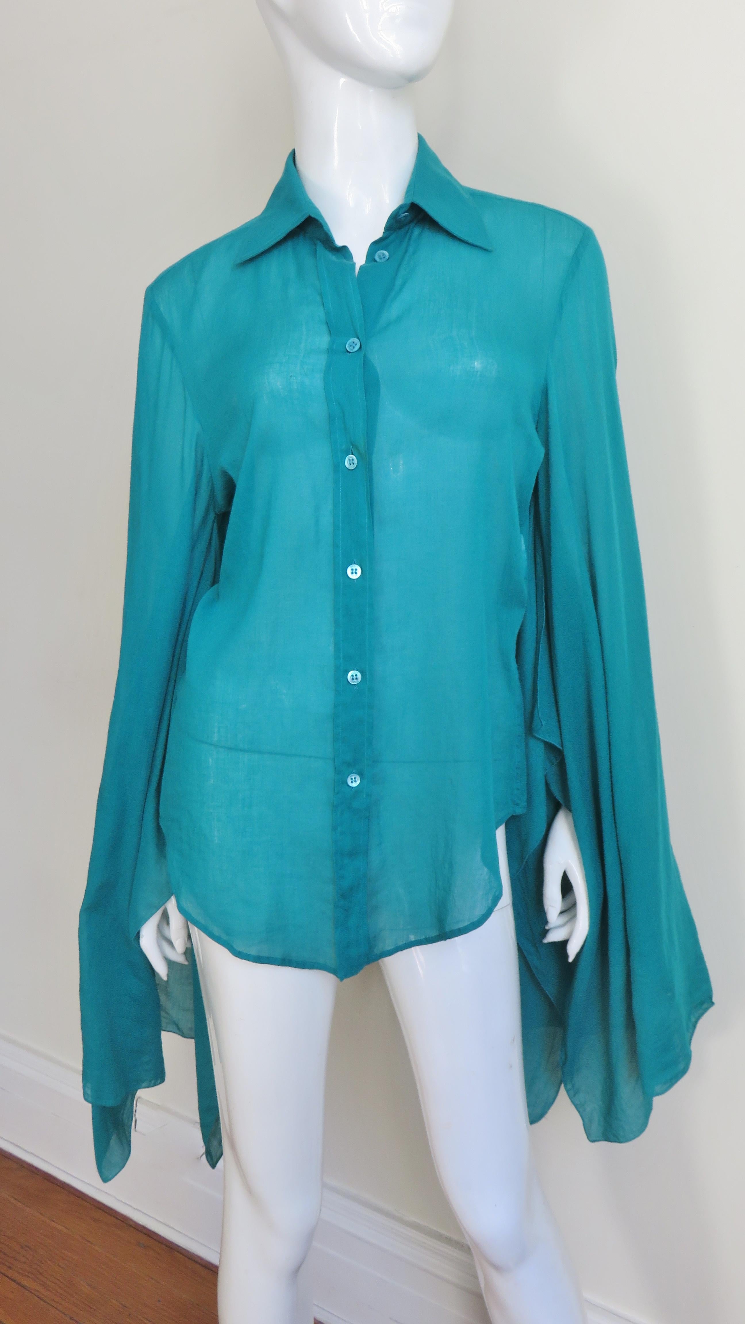 A beautiful  blue green cotton top from Gucci.  It buttons up the front with Gucci engraved mother of pearl buttons and has a shirt collar, back yoke, shirt tail hem and long draping angel sleeves.  
Fits sizes Small, Medium.

Bust  39