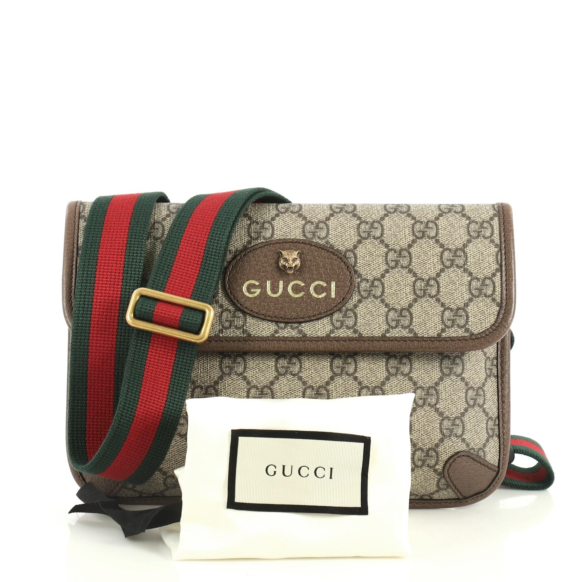 This Gucci Animalier Flap Belt Bag GG Coated Canvas, crafted in brown GG coated canvas, features an adjustable nylon Web belt with buckle closure, oval Gucci leather tag with feline head, leather trim and aged gold-tone hardware. Its magnetic snap