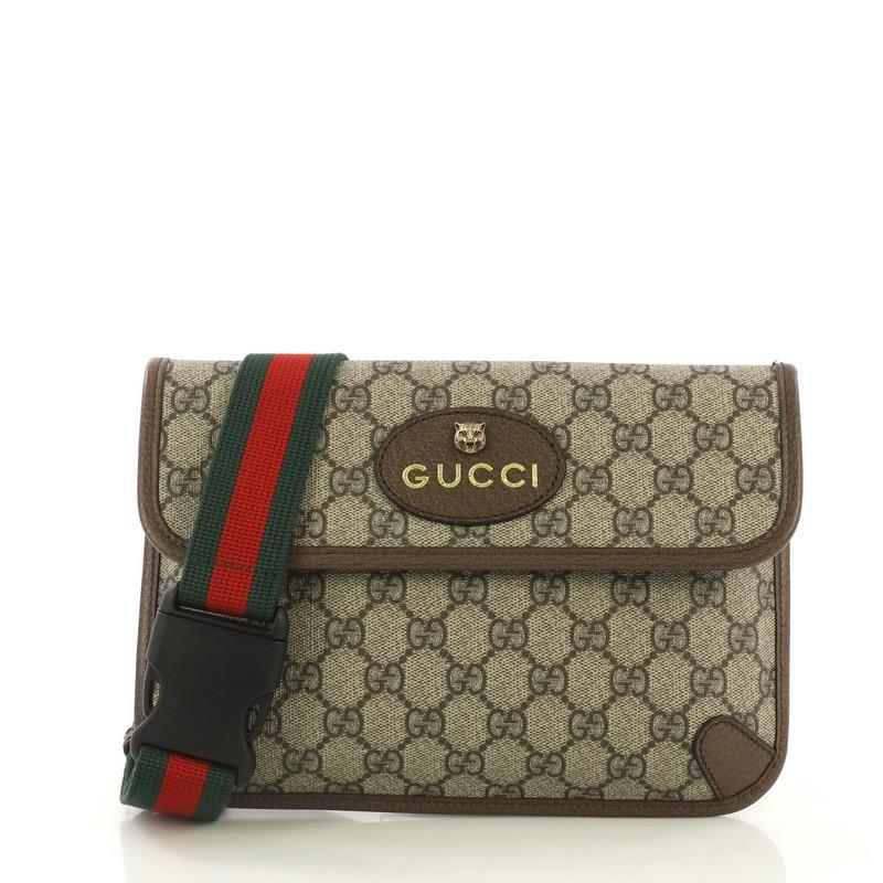 This Gucci Animalier Flap Belt Bag GG Coated Canvas, crafted in brown GG coated canvas, features an adjustable nylon web belt with buckle closure, oval Gucci leather tag with feline head, leather trim, and aged gold-tone hardware. Its magnetic snap