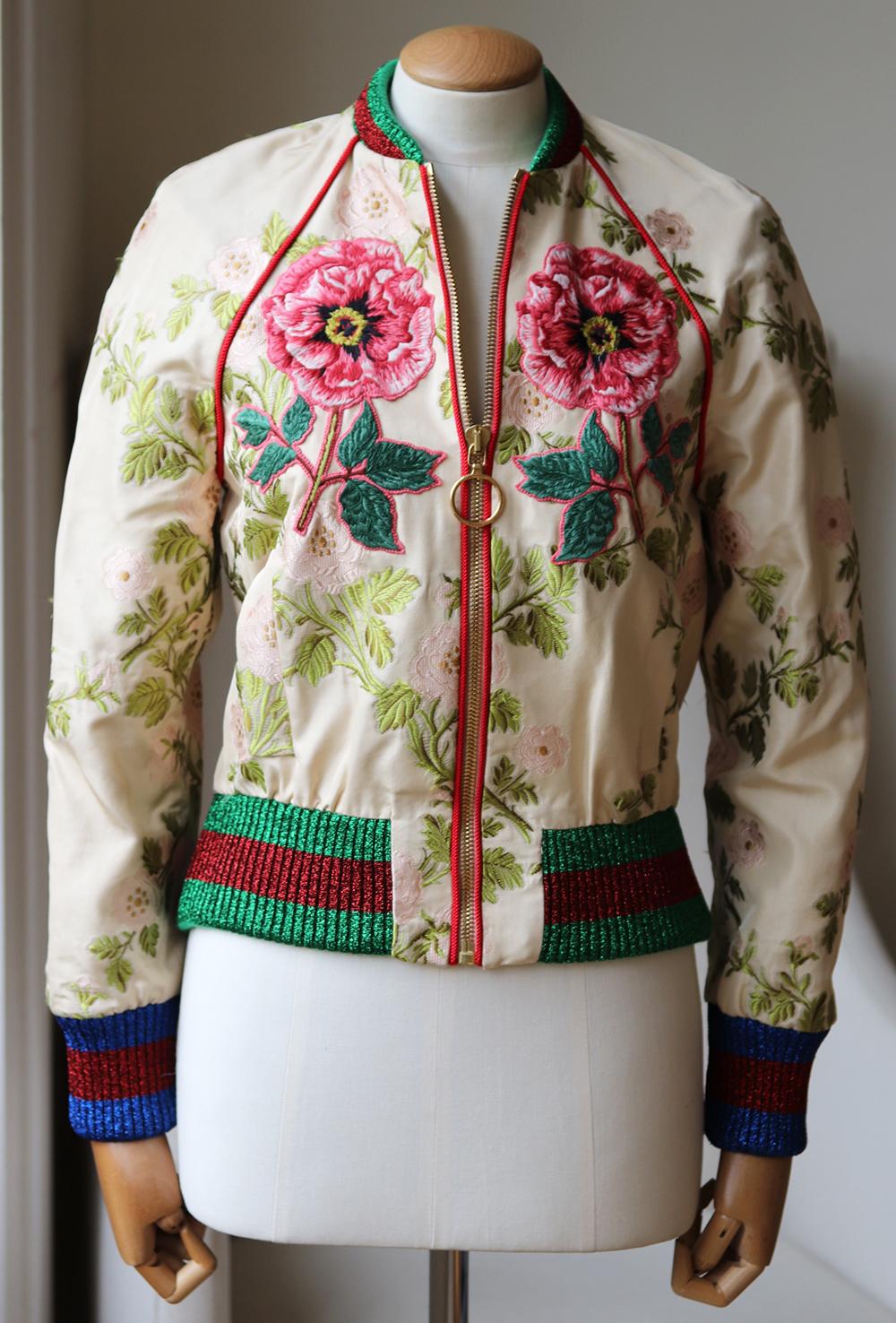 Gucci's statement bomber jackets have been a key feature of every season as they are easy to dress up or down. 
Designed with the brand's signature metallic blue and red ribbed trims, this silk floral brocade style is decorated with appliqués in a