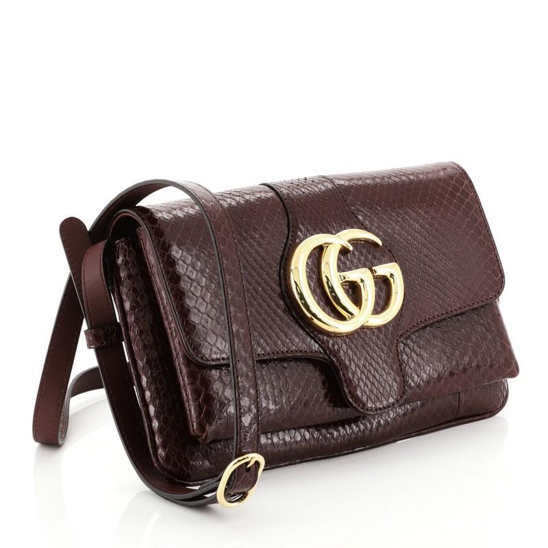 This Gucci Arli Shoulder Bag Python Small, crafted from genuine red python, features an adjustable strap, flap top with GG logo, and gold-tone hardware. Its magnetic snap closure opens to a neutral leather interior with zip pocket.  This item can