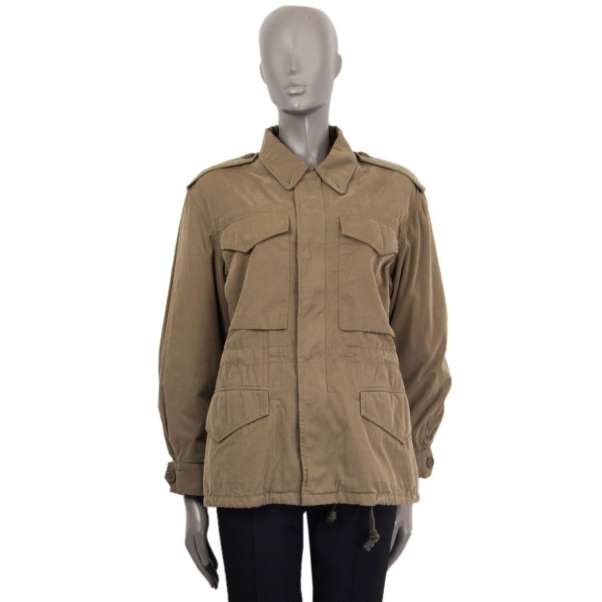 Gucci parka jacket in army green cotton (100%) complete with epaulettes and cargo pockets. The label's logo is printed across the back in yellow, green, red and black. Concealed snaps and zip fastening through front. Comes with a detachable cozy