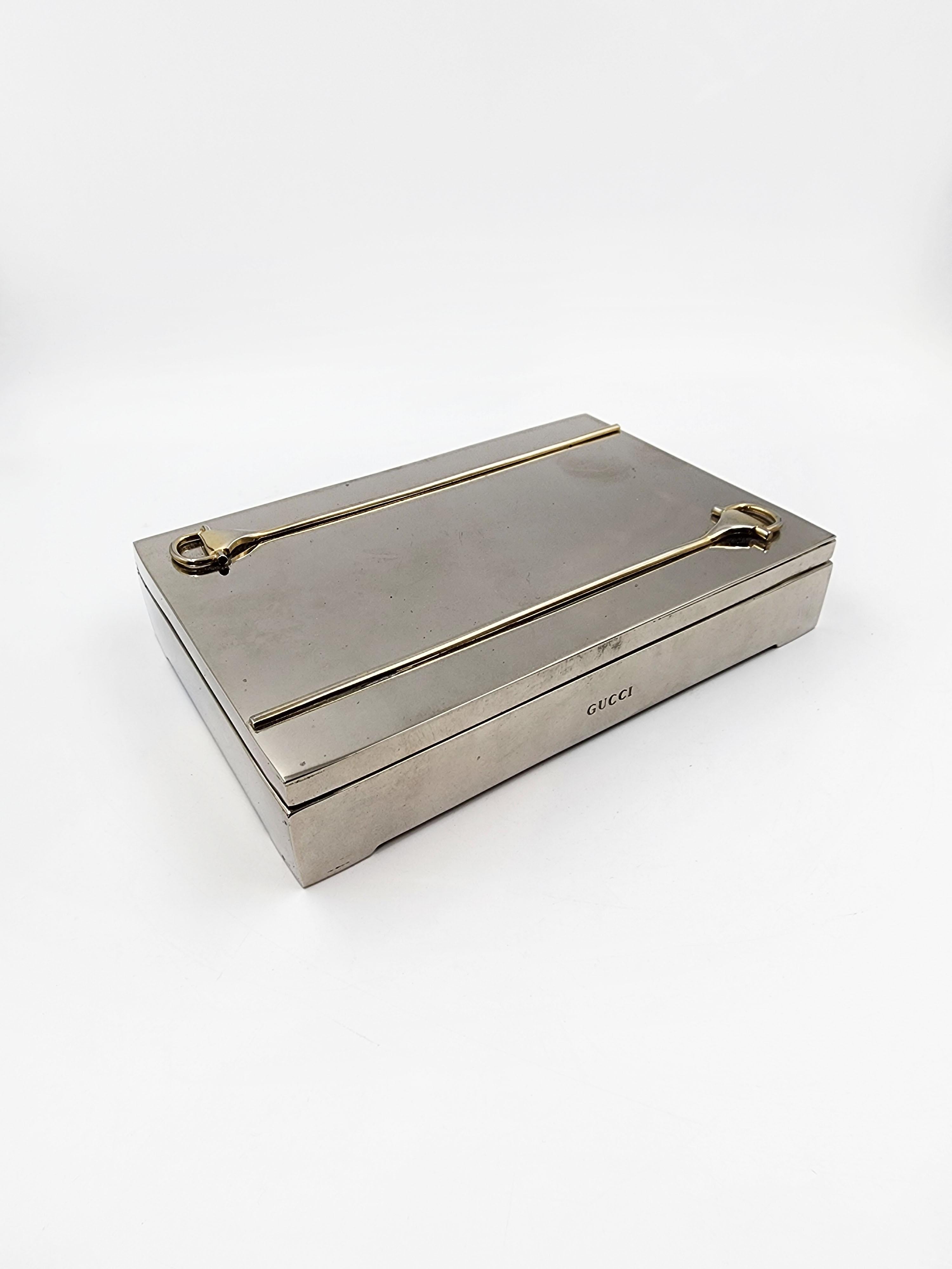 Estuche de tabaco de metal plateado Art Déco Gucci
Elegante tabaquera Gucci de metal plateado, con detalles de herradura dorada.
Medidas:
Altura: 3 centímetros
Longitud: 15 centímetros
Profundidad: 10 centímetros