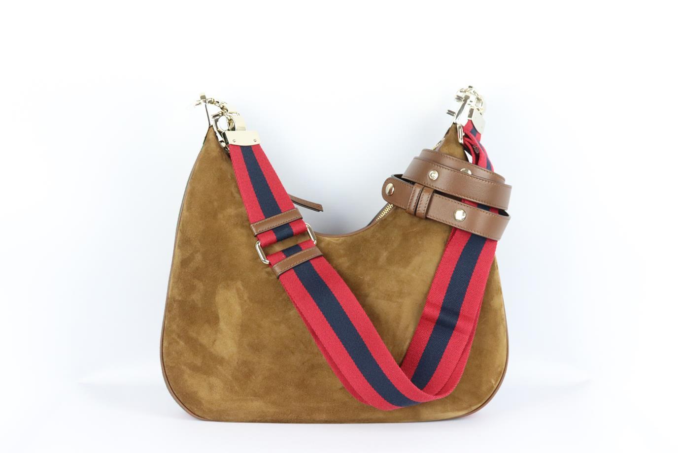 Gucci Attache large webbing trimmed suede shoulder bag. Brown, green, navy and red. Zip fastening at top. Comes with dustbag and additional shoulder strap. Protective plastic attached. Height: 13 in. Width: 13.6 in. Depth: 2 in. Strap Drop: 19 in.