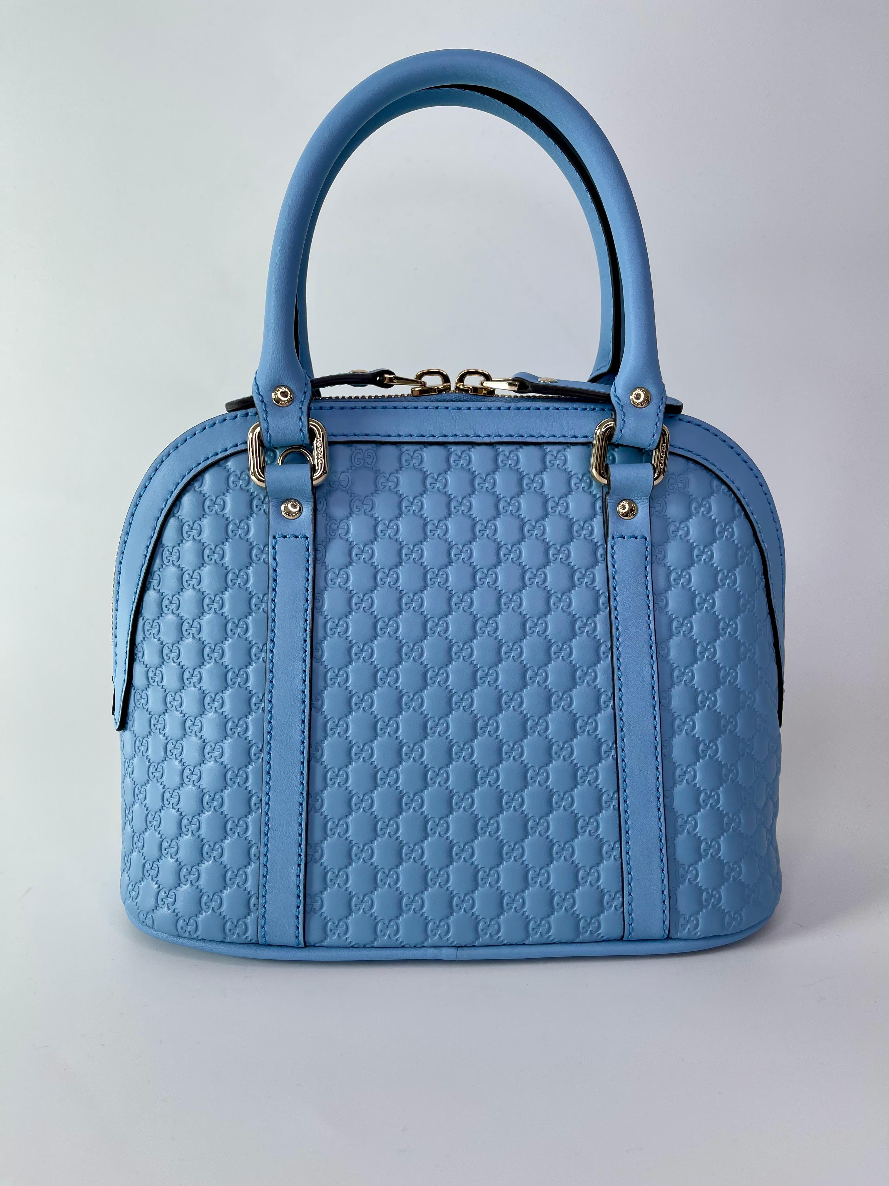 This bag is made with embossed microguccissima calf leather in light baby blue. The bag features dual rolled leather top handles, an optional shoulder strap and polished light gold hardware. The zipper opens to a spacious beige fabric interior with
