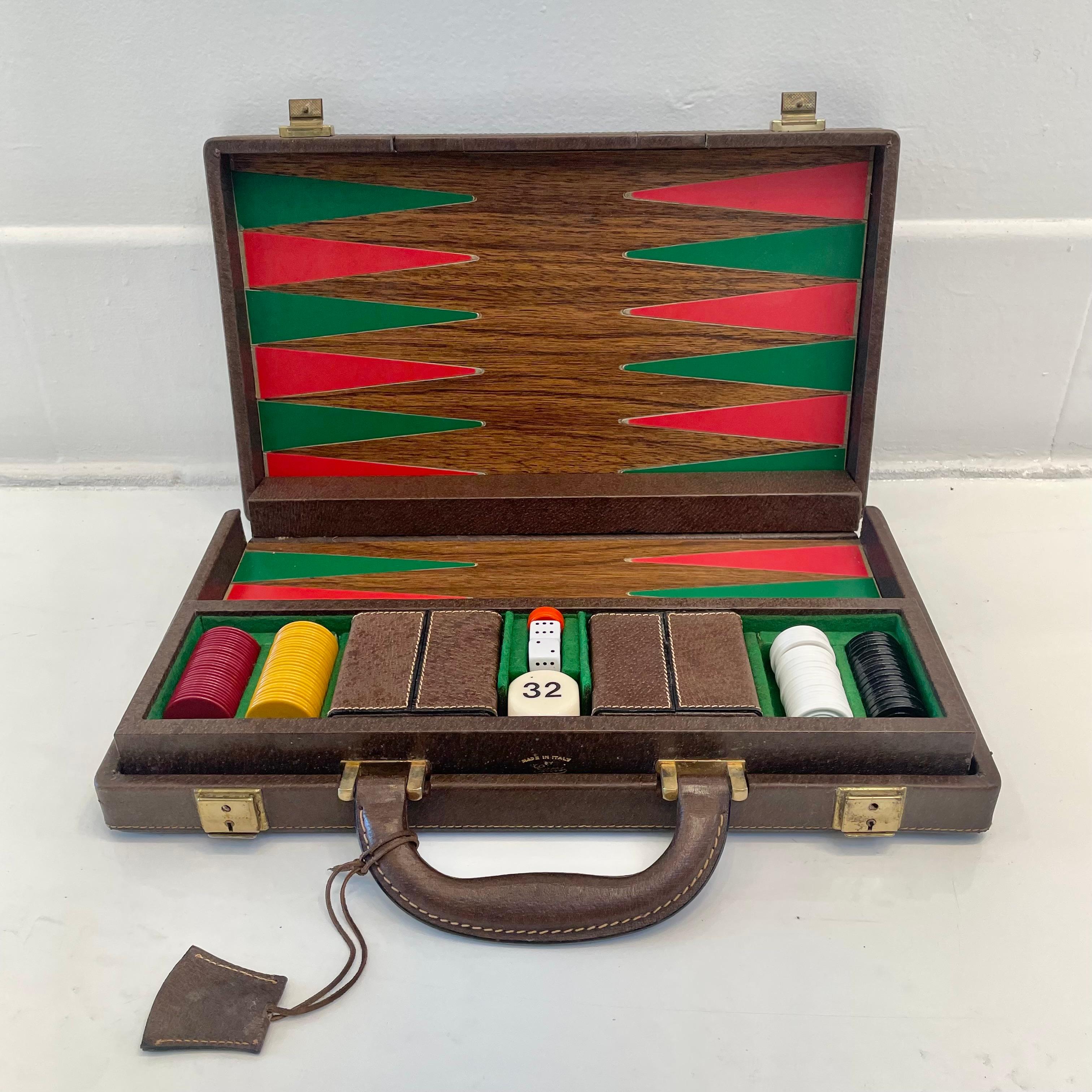 Vintage portable Gucci leather game case with backgammon and a small set of poker chips. Wood framed case wrapped in an elegant canvas with leather accents. Tan canvas features a classic pattern of the repeating and interlocking Gucci 