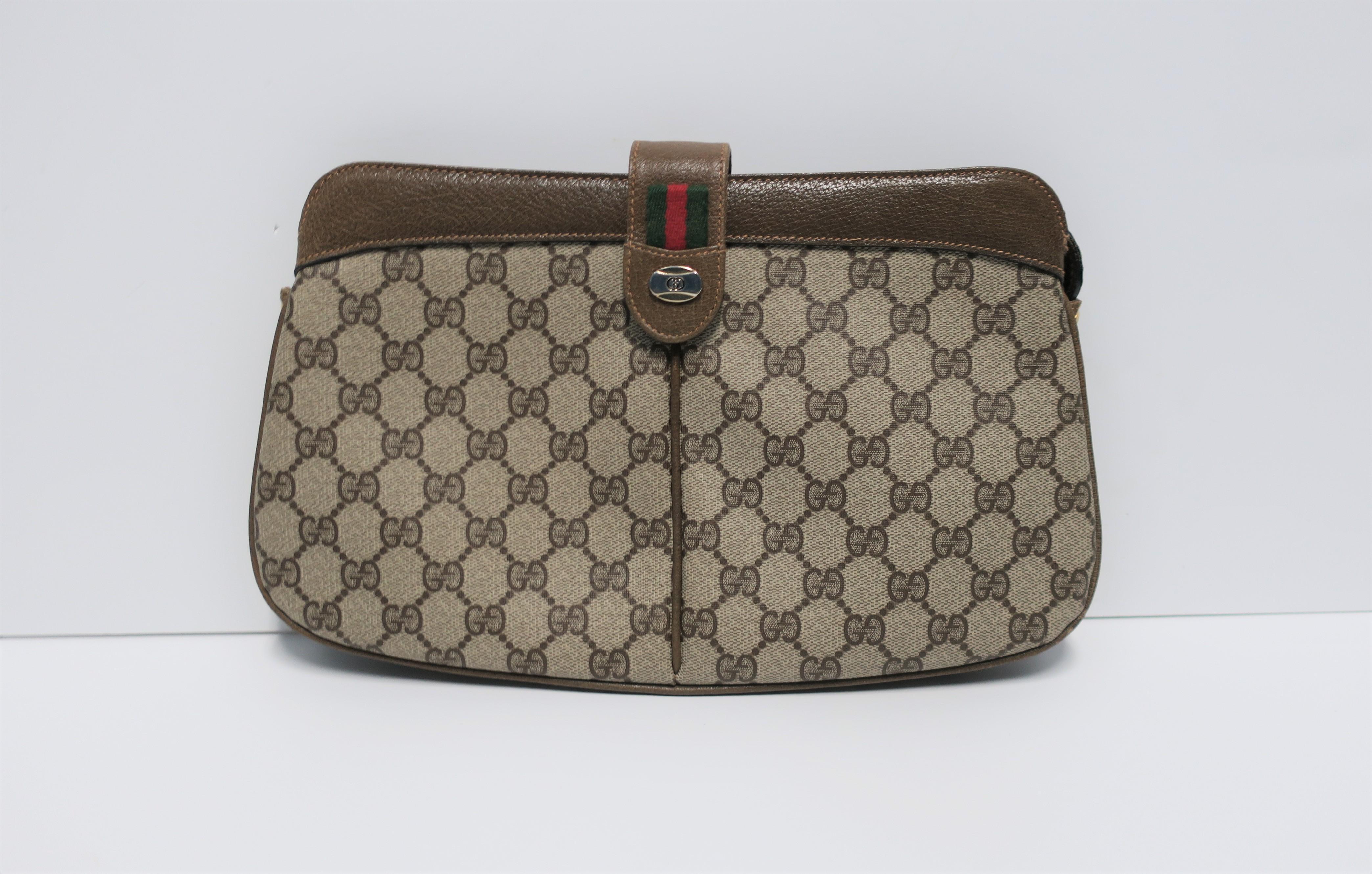 A chic classic authentic Gucci clutch handbag featuring its iconic 'G' tan canvas, tan/brown leather trim and piping, red/green racing stripe, and two-tone metal Gucci logo. Marked 'Gucci' and 'Made in Italy' on interior leather tag (see image #6.)