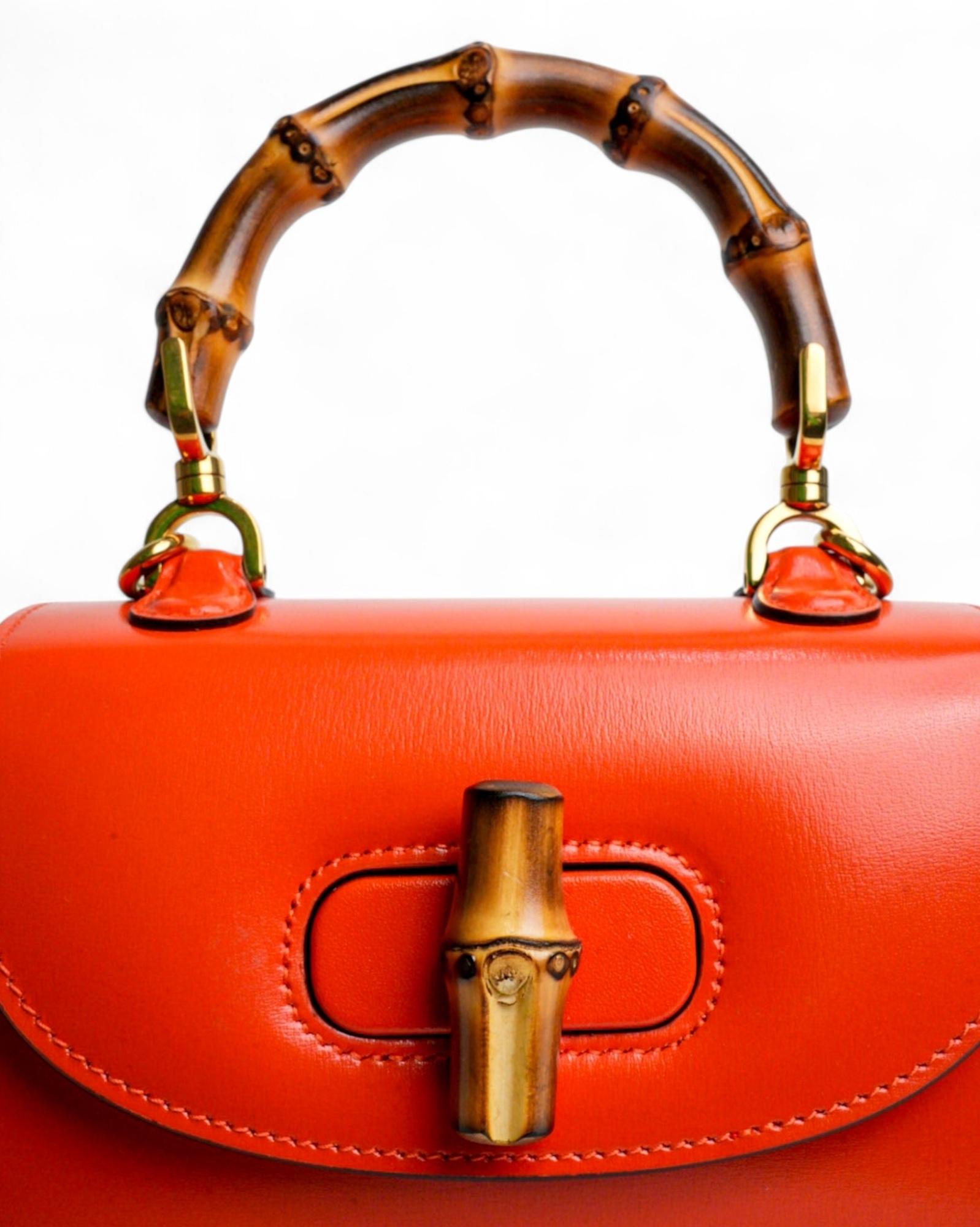 Gucci's signature bag, Bamboo 1947 line in Mini size, made of shiny leather in the refined orange color, with gold hardware. The model features a front flap with a swivel closure, while the interior, lined in beige canvas, offers a small pocket and