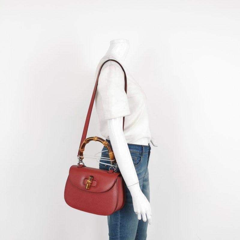 Gucci Bamboo 1947 Top Handle Bag Leather Small Burgundy with Strap
These are professional photos of the actual bag.
  This Gucci crossbody bag has the signature oval design with the bamboo turn lock.
  CONDITION: EXCELLENT
  Light rubbing around the