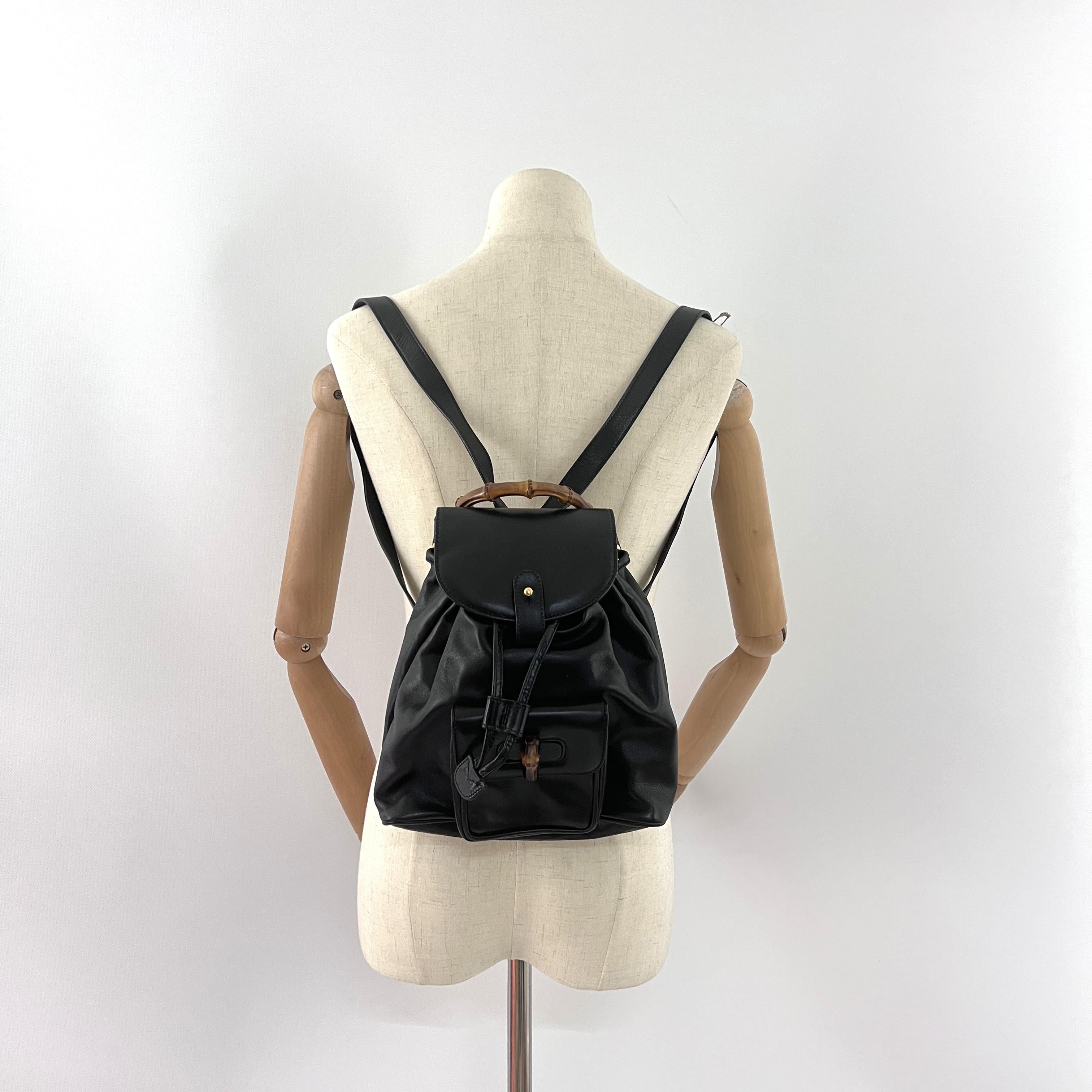 Sac à dos Bamboo de GUCCI en cuir noir avec accessoires en métal doré. Le sac est doté d'un cordon de serrage et d'une fermeture à glissière sur la poche extérieure. L'intérieur se compose d'un compartiment principal et d'une poche plaquée zippée.