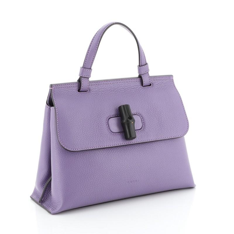 This Gucci Bamboo Daily Top Handle Bag Leather Small, crafted from purple leather, it features a flat top handle and silver-tone hardware. Its flap with bamboo turn-lock closure opens to a neutral printed fabric interior with zip and slip pockets.
