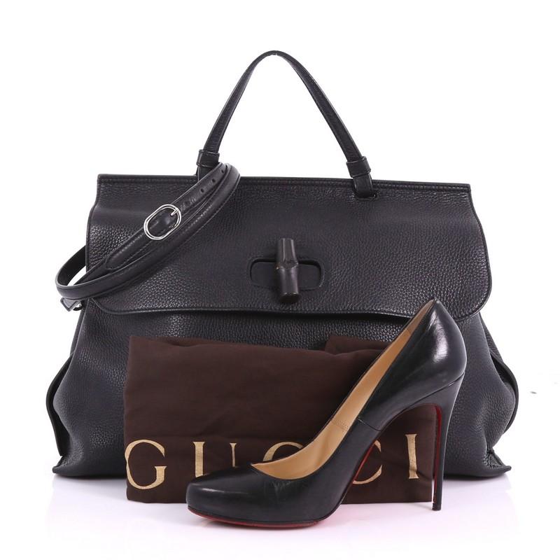 This Gucci Bamboo Daily Top Handle Bag Leather Large, crafted from black leather, features flat top handle, and silver-tone hardware. Its flap with bamboo turn-lock closure opens to a multicolor fabric interior with slip pockets. **Note: Shoe