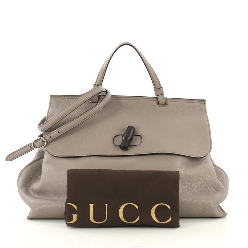 This Gucci Bamboo Daily Top Handle Bag Leather Large, crafted from gray leather, features flat top handle and silver-tone hardware. Its flap with bamboo turn-lock closure opens to a multicolor fabric interior with zip and slip pockets.

Estimated