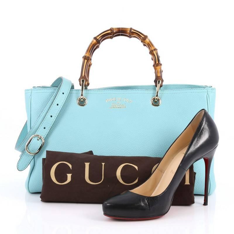 This authentic Gucci Bamboo Shopper Tote Leather Medium is a classic must-have. Crafted from aqua blue leather, this simple yet stylish tote features Gucci's signature sturdy bamboo handles, protective base studs, stamped logo at the front, and