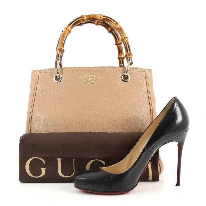 This authentic Gucci Bamboo Shopper Tote Leather Small is a classic must-have. Crafted in nude leather, this simple yet stylish tote features Gucci's signature sturdy bamboo handles, protective base studs, stamped logo at the front and bamboo and