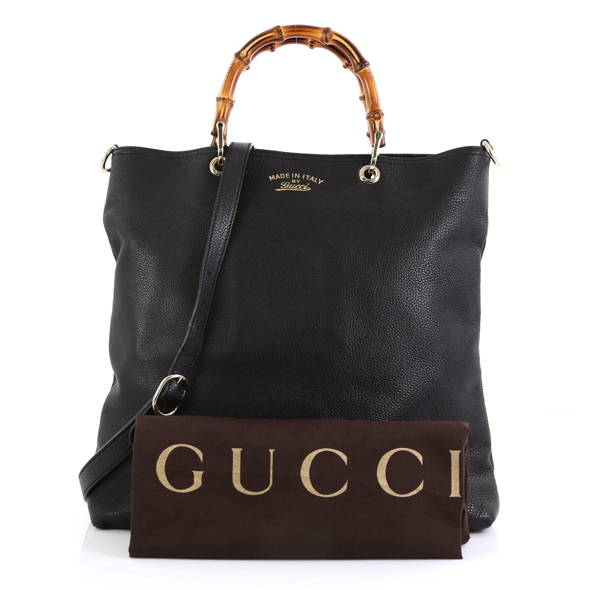 This Gucci Bamboo Shopper Tote Leather Tall, crafted in black leather, features sturdy bamboo handles, stamped logo at the front and gold-tone hardware. Its hidden magnetic snap closure opens to a black fabric interior with side zip and slip